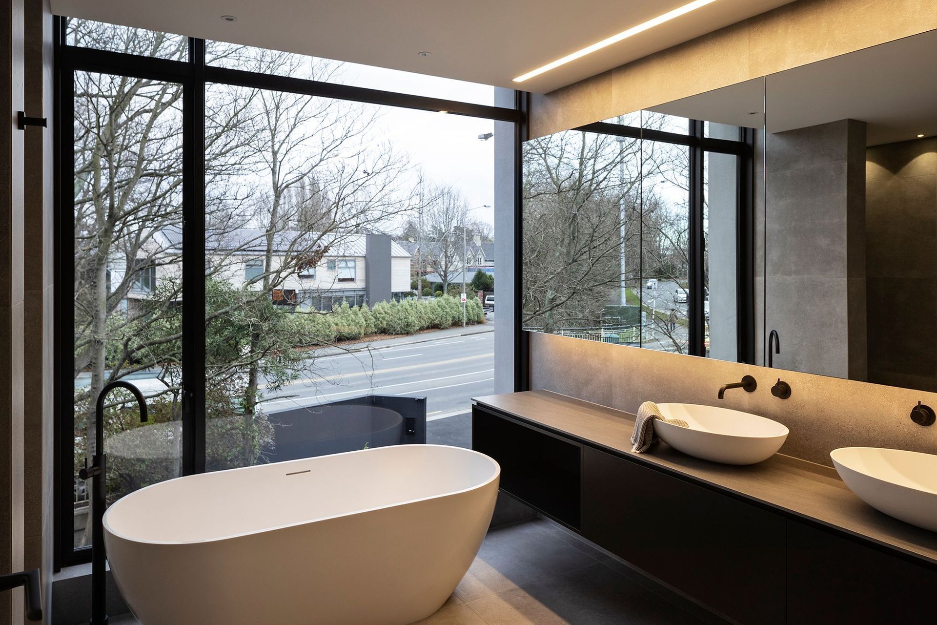 The floor-to-ceiling window allows for ample natural light to penetrate into this ensuite bathroom. A retractable blind provides privacy as needed.