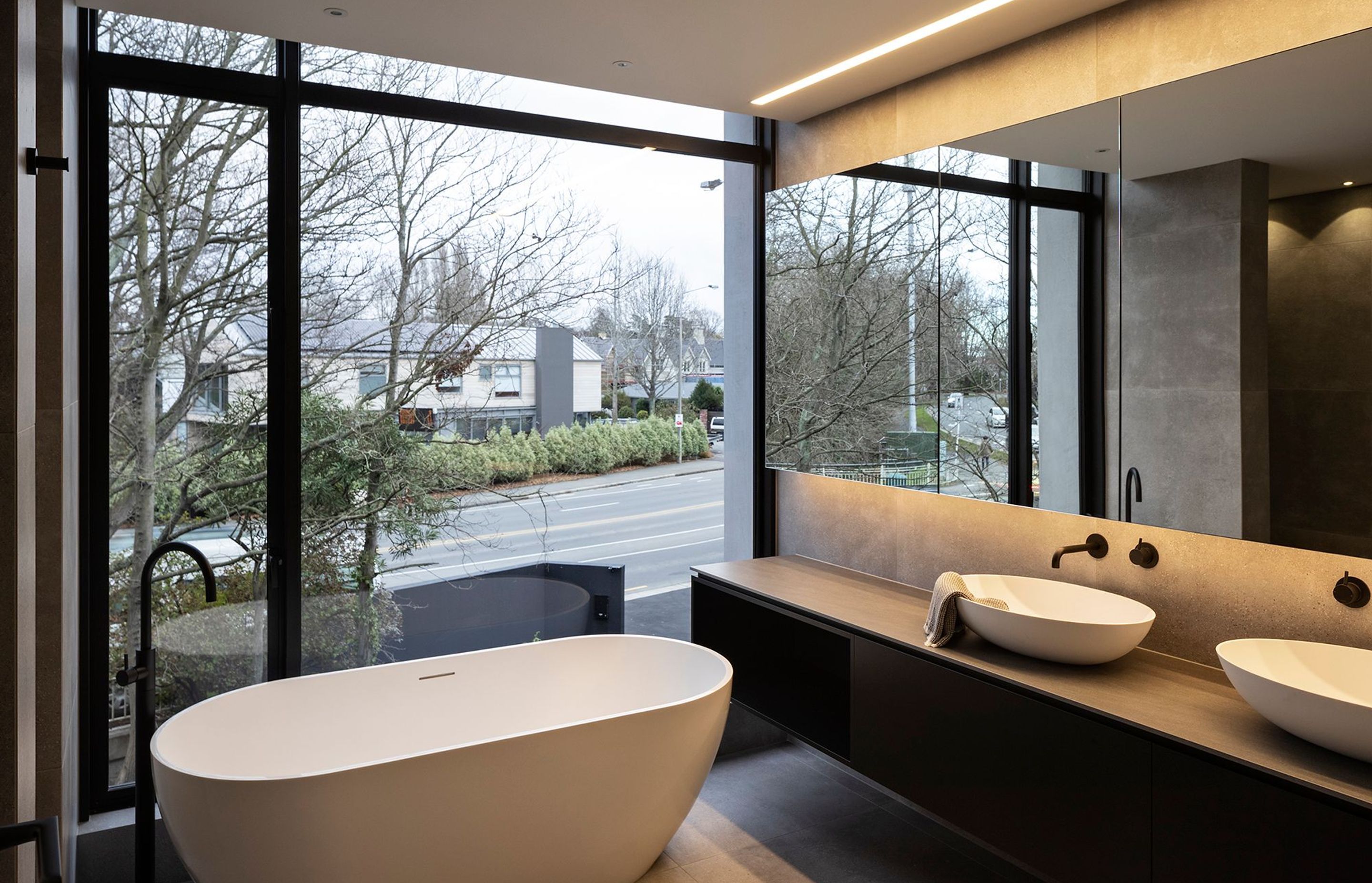 The floor-to-ceiling window allows for ample natural light to penetrate into this ensuite bathroom. A retractable blind provides privacy as needed.