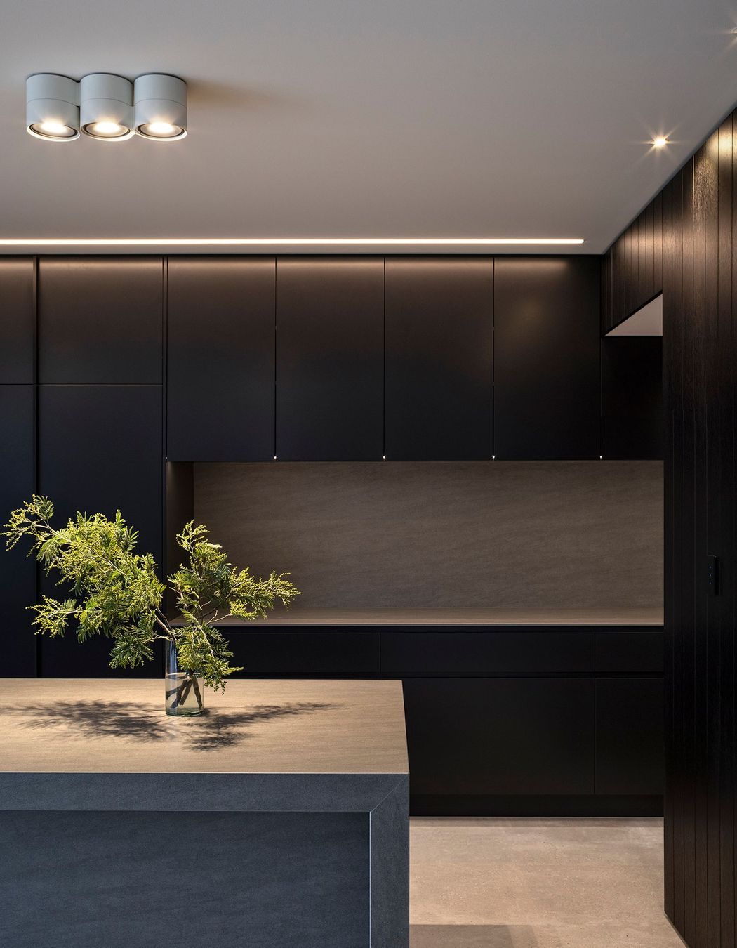 Bold lines and dark tones impart a masculine feel, which is tempered by the richly textured materials.