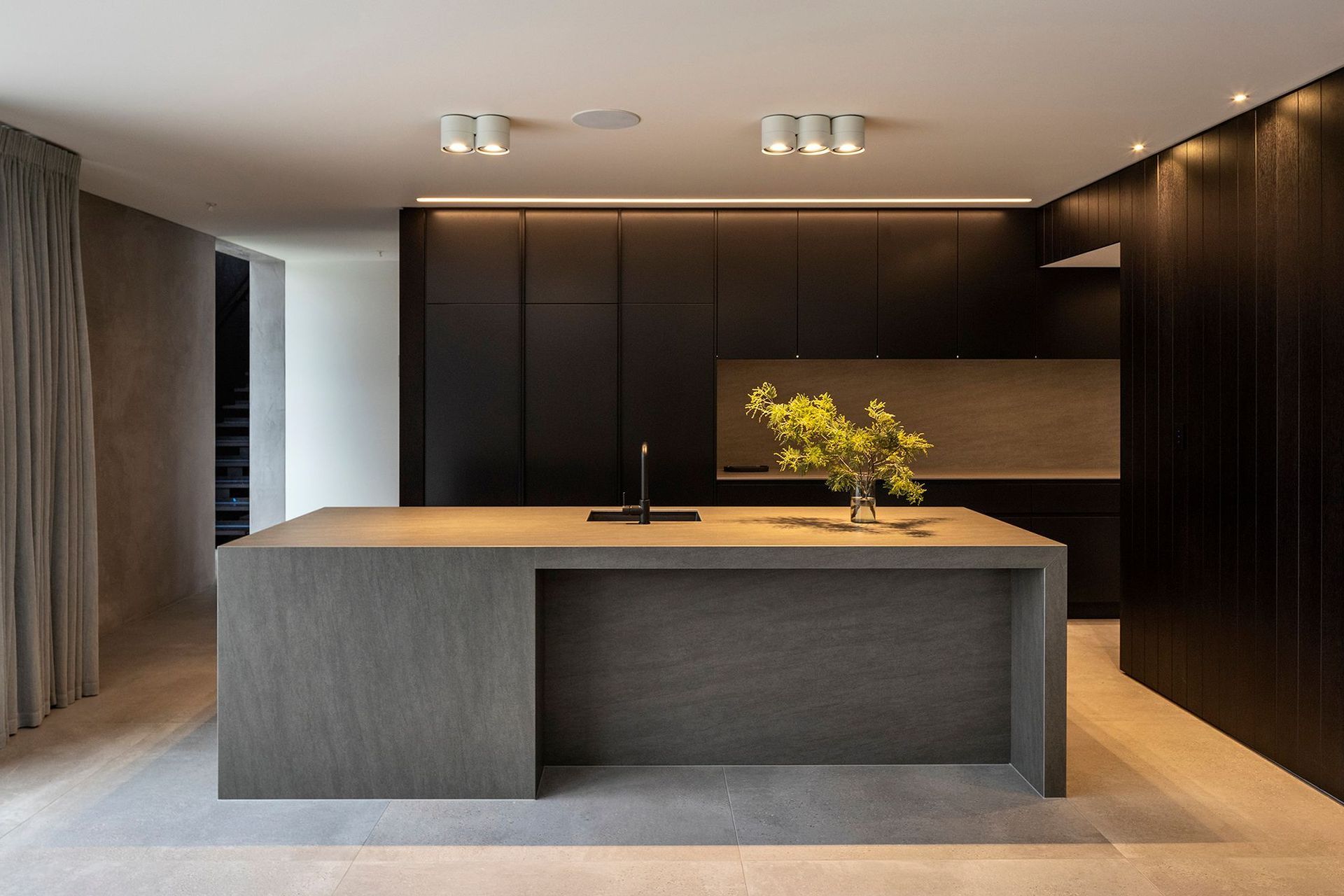 The kitchen is carefully detailed with the functional cooking area concealed in a separate annex, allowing the occupants to enjoy the primary space without clutter.