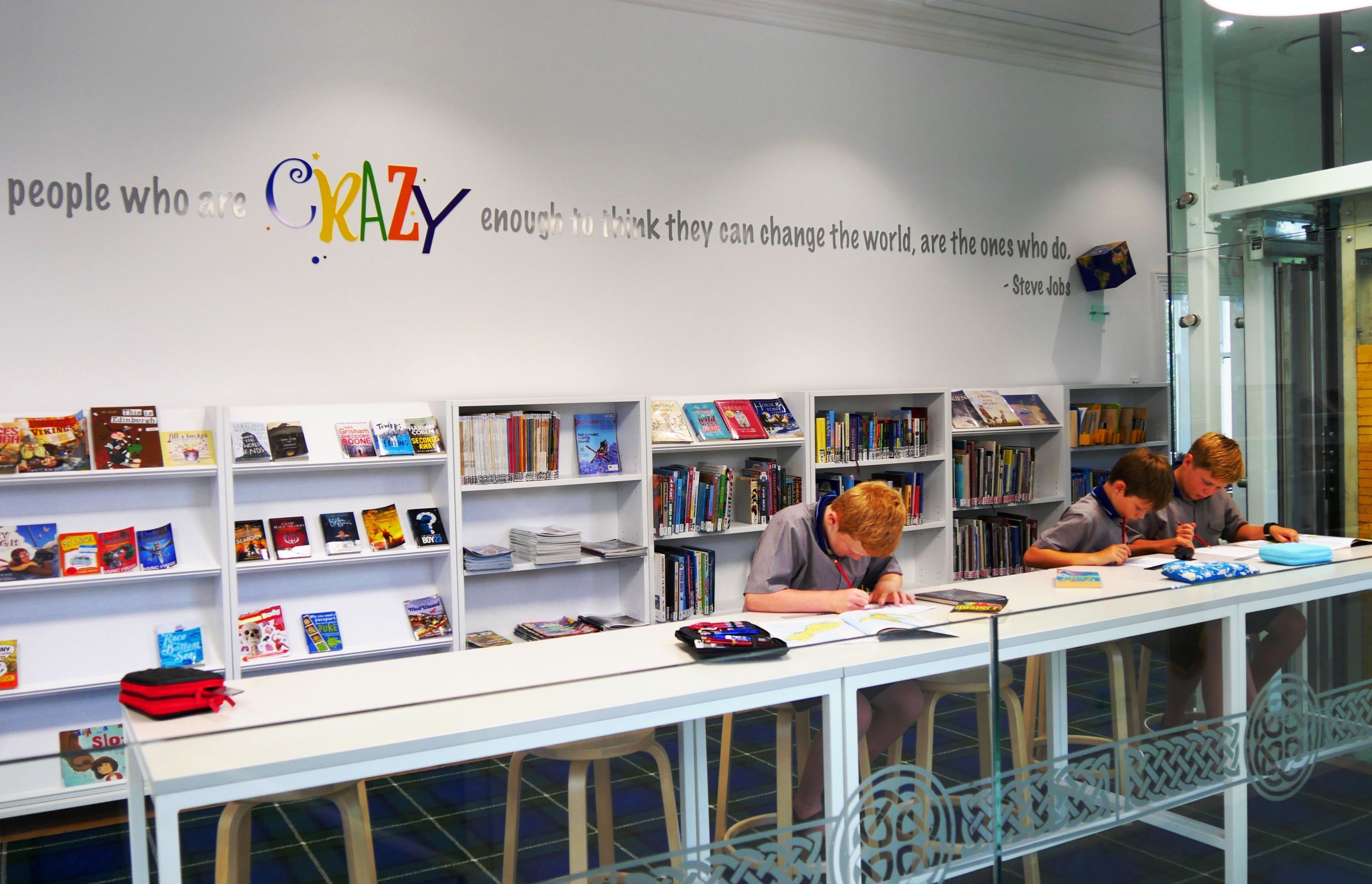 Books are hero, and inspirational messages adorn the walls. School insignia adorn the glazing balustrades.