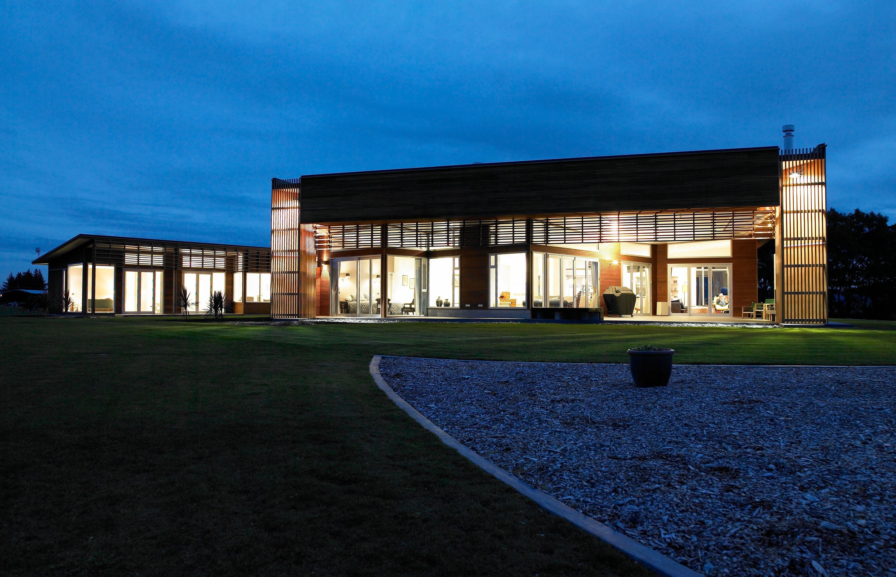 White light shines during the blue hour whilst timber creates patterns on the walls.