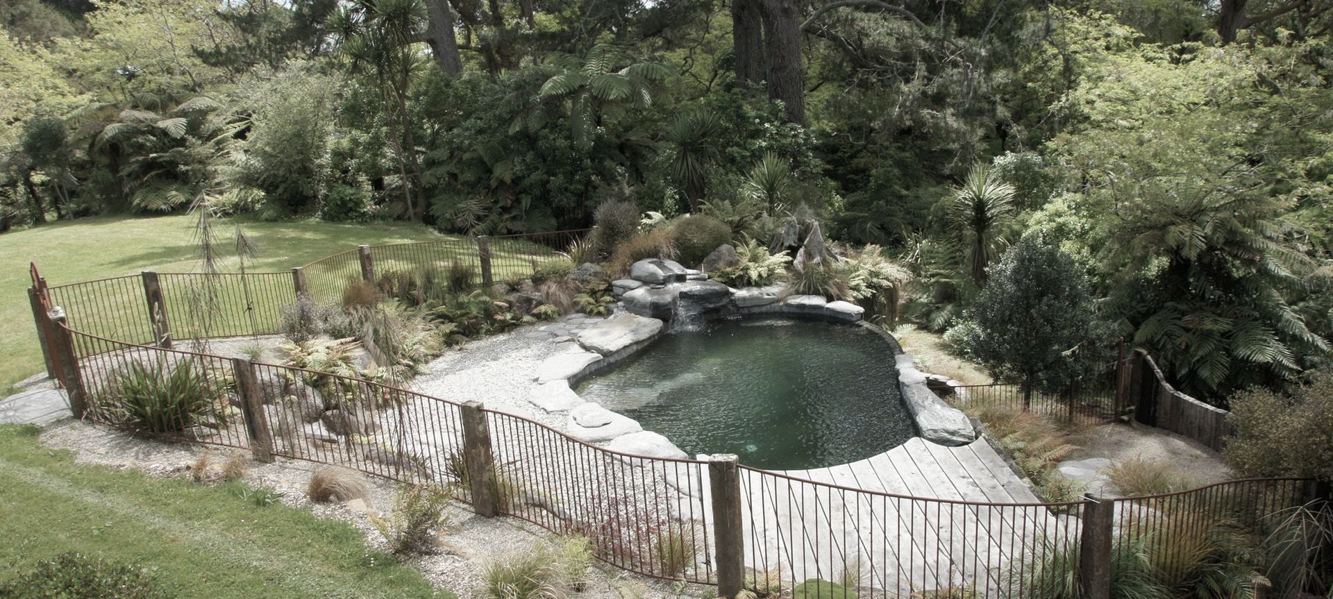 Infinity edge natural style swimming pool and Corten steel pool fencing
