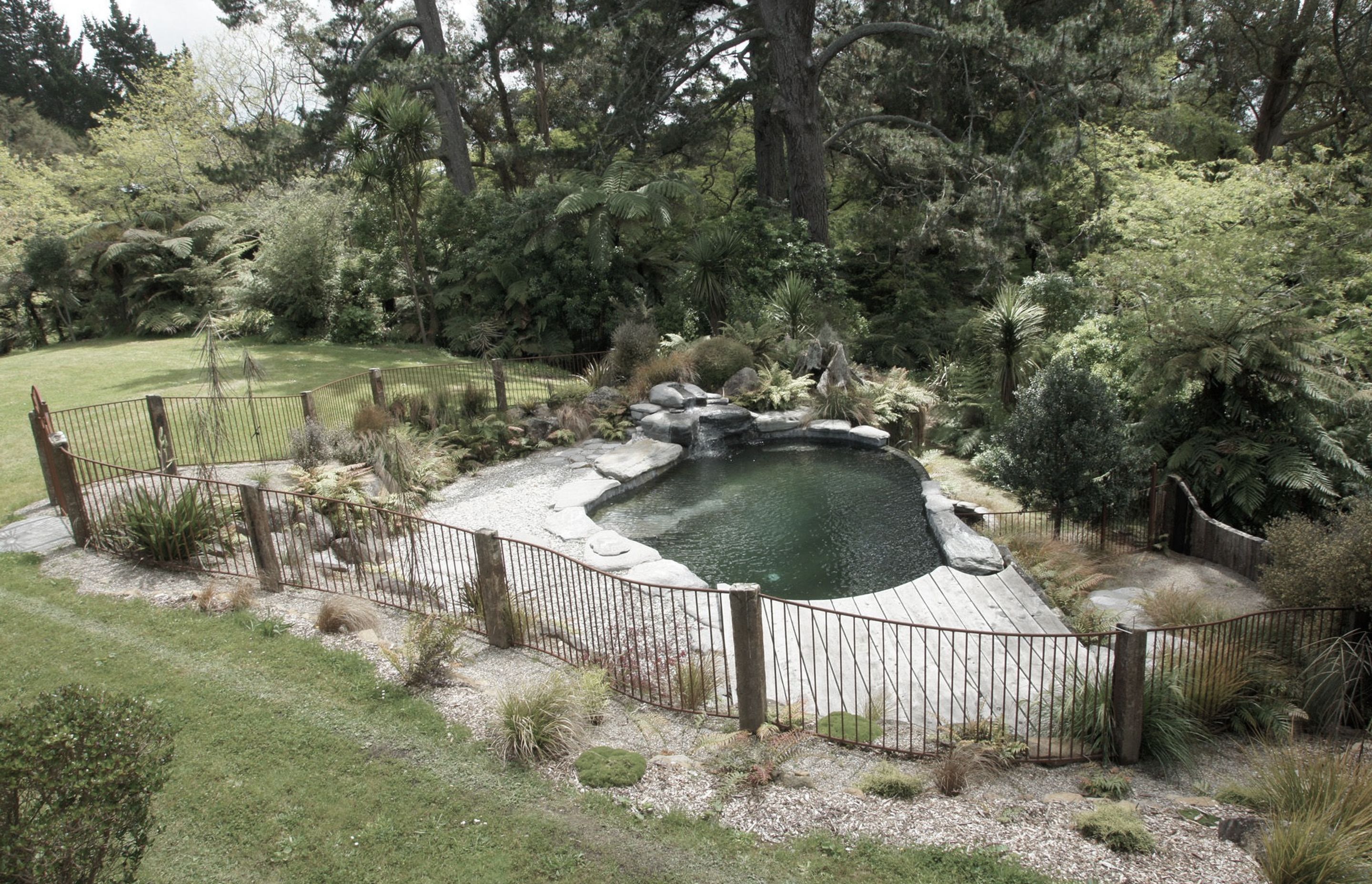 Infinity edge natural style swimming pool and Corten steel pool fencing