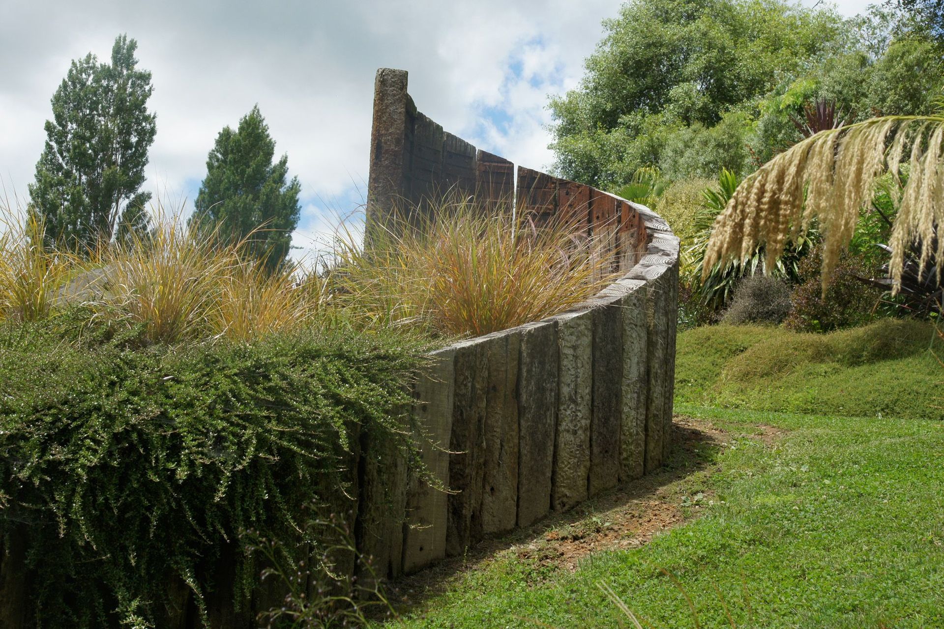 Recycled railway sleeper curved retaining - chainsaw sculpted