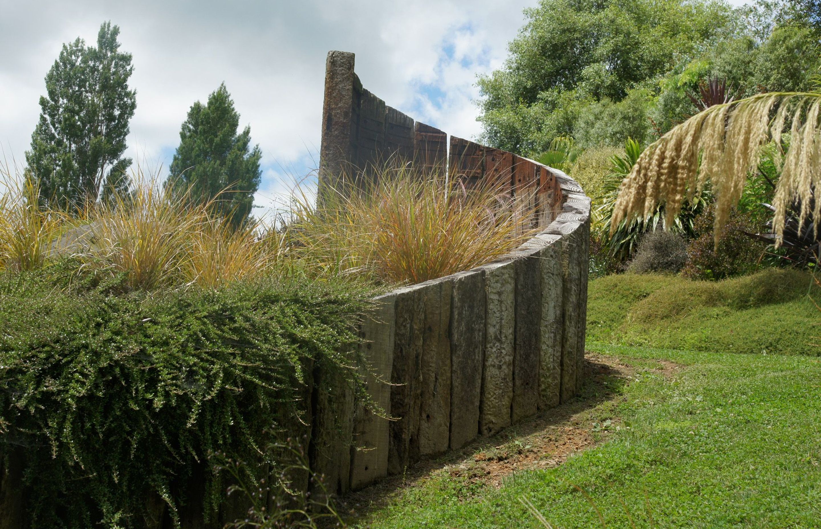 Recycled railway sleeper curved retaining - chainsaw sculpted