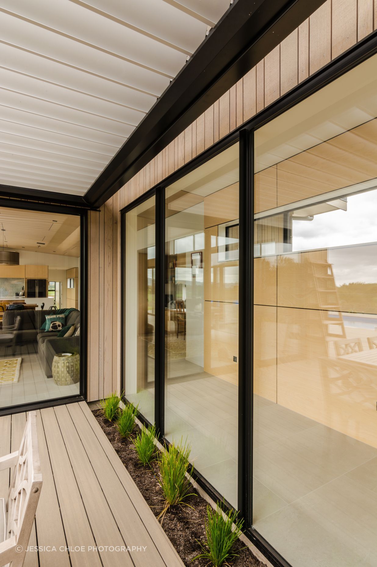 The covered outdoor kitchen looks back at the feature ply breezeway.