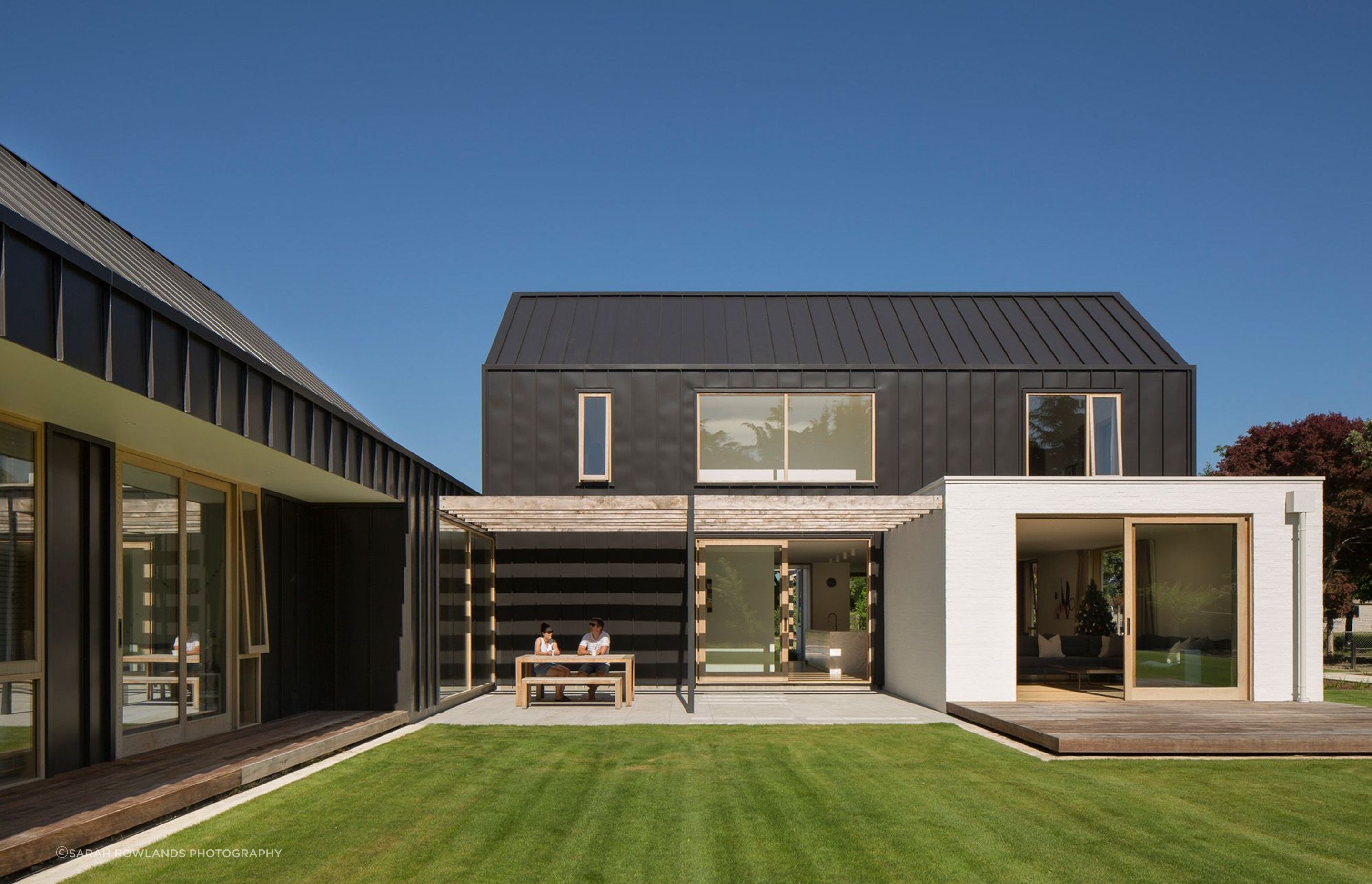 Natural light and shade is carefully controlled throughout this home. Here, a recessive courtyard with a pergola provides shade and shelter from the sun and wind.