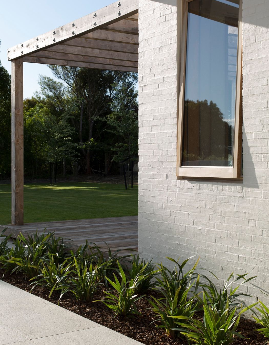 Textured bagged brick walls in Dulux 'Dannevirke paint with custom-built timber joinery.