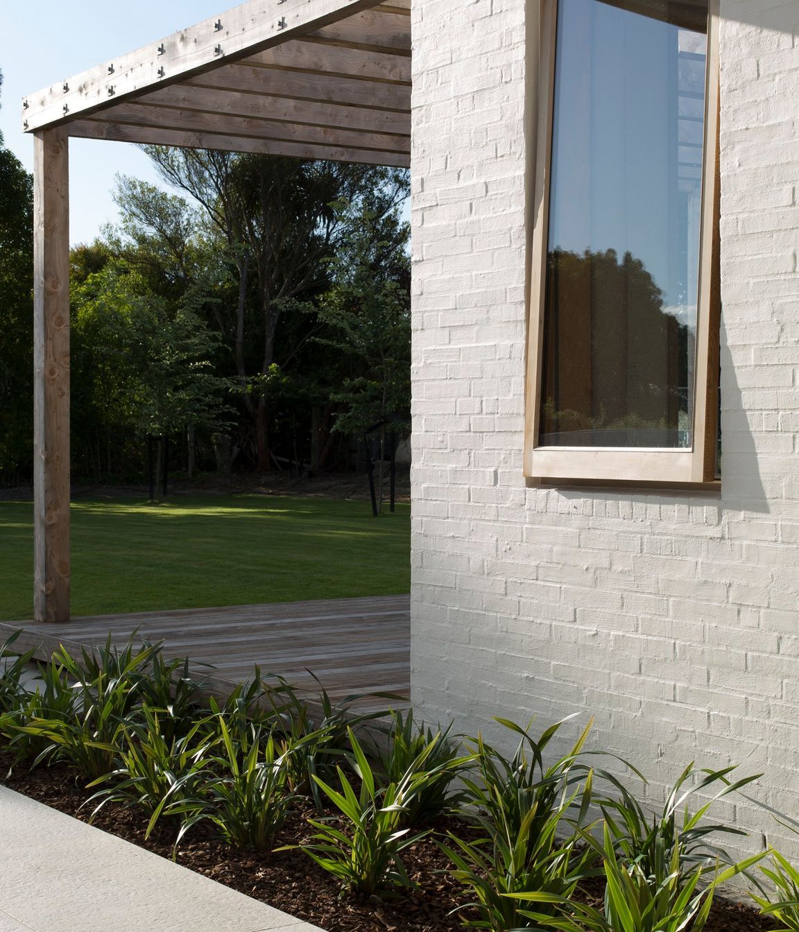 Textured bagged brick walls in Dulux 'Dannevirke paint with custom-built timber joinery.