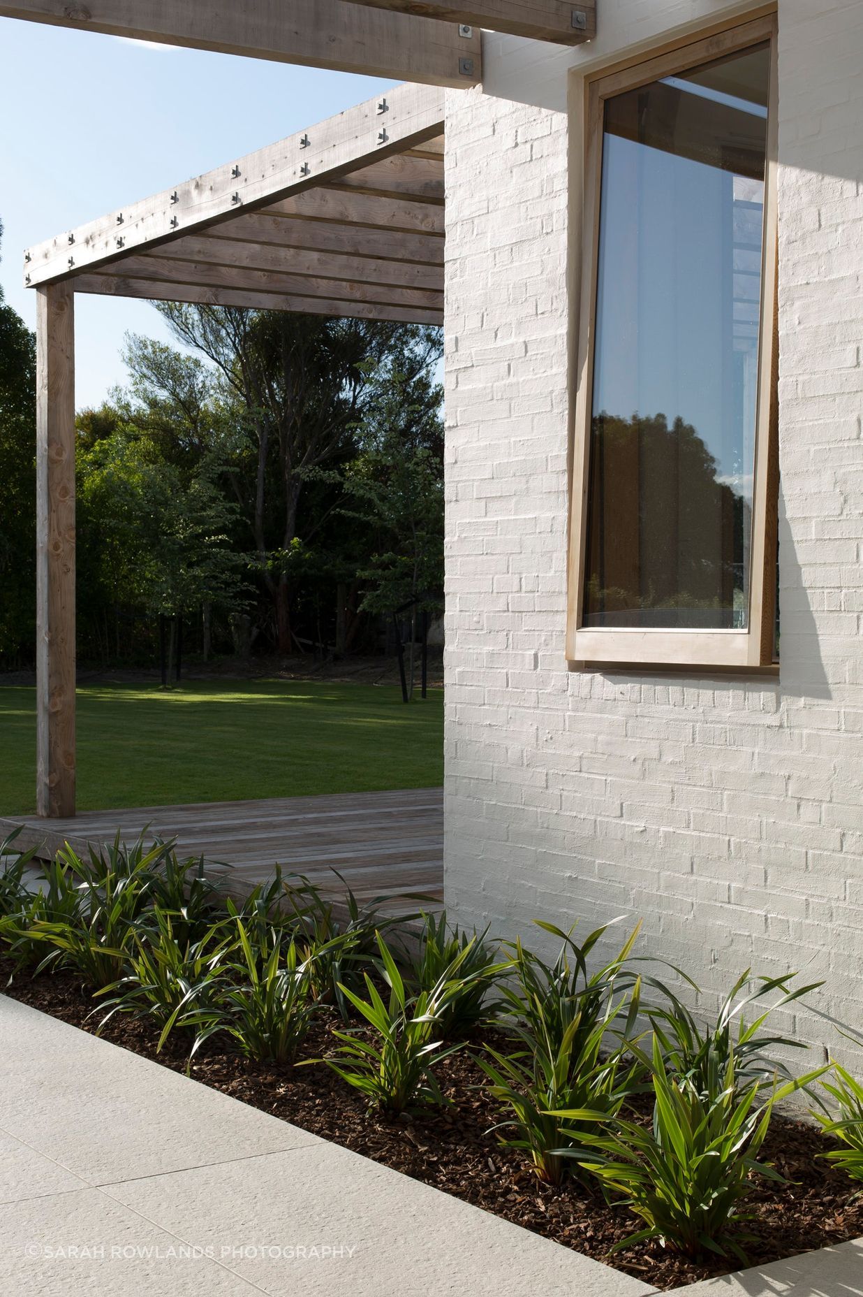 Textured bagged brick walls in Dulux 'Dannevirke paint with custom-built timber joinery.