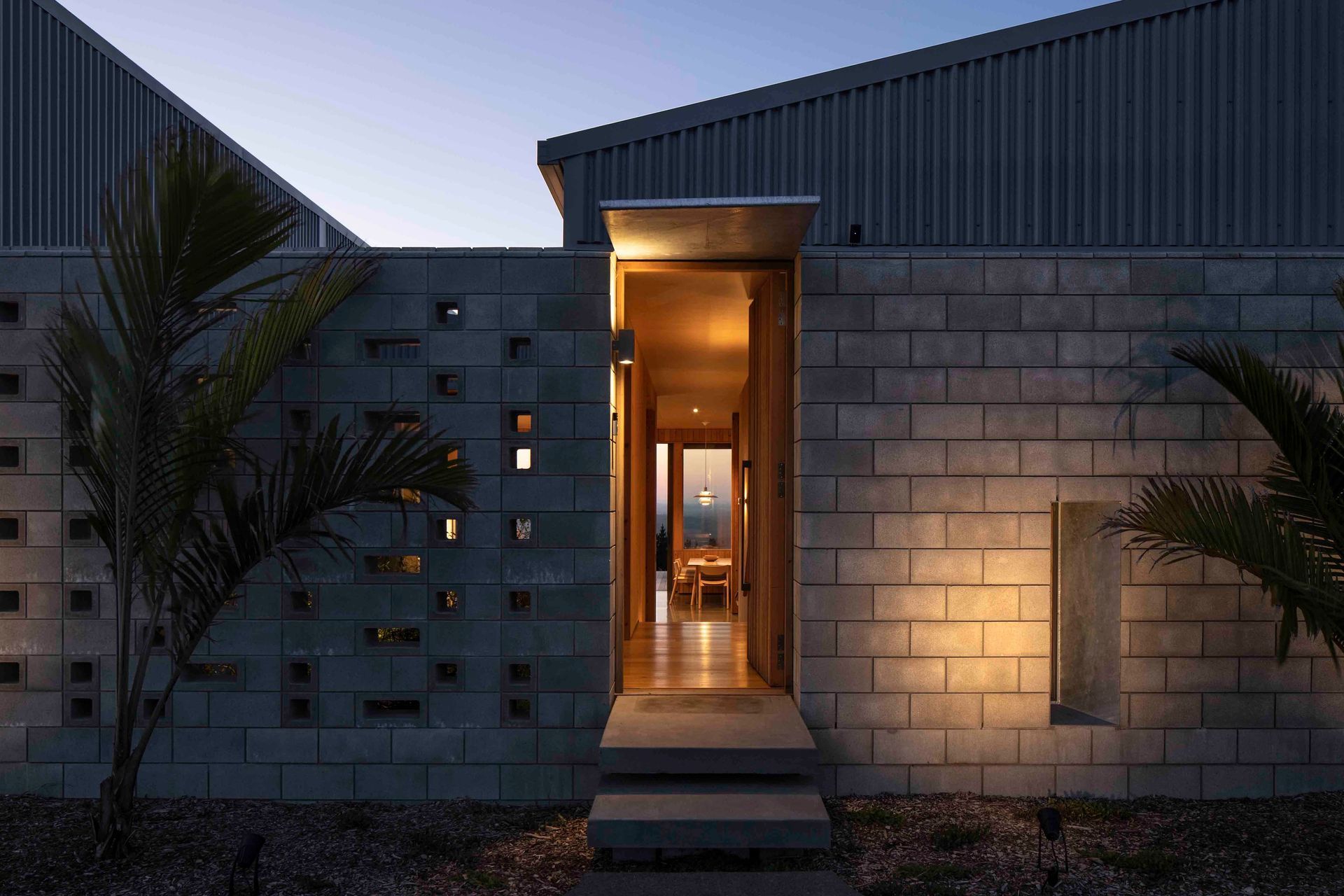 The entry way features a perforated block wall that ties directly into the structure of the home.