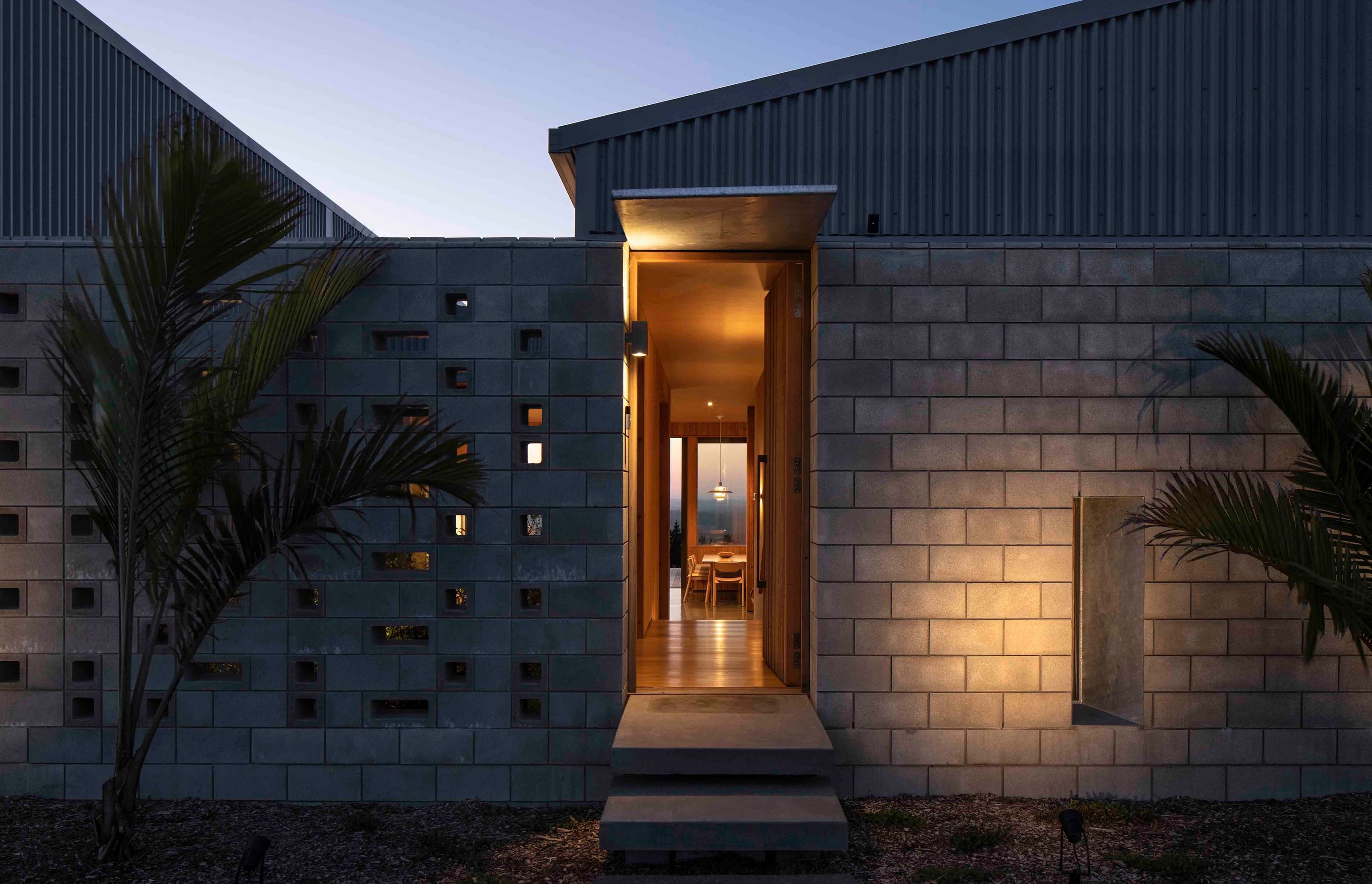 The entry way features a perforated block wall that ties directly into the structure of the home.