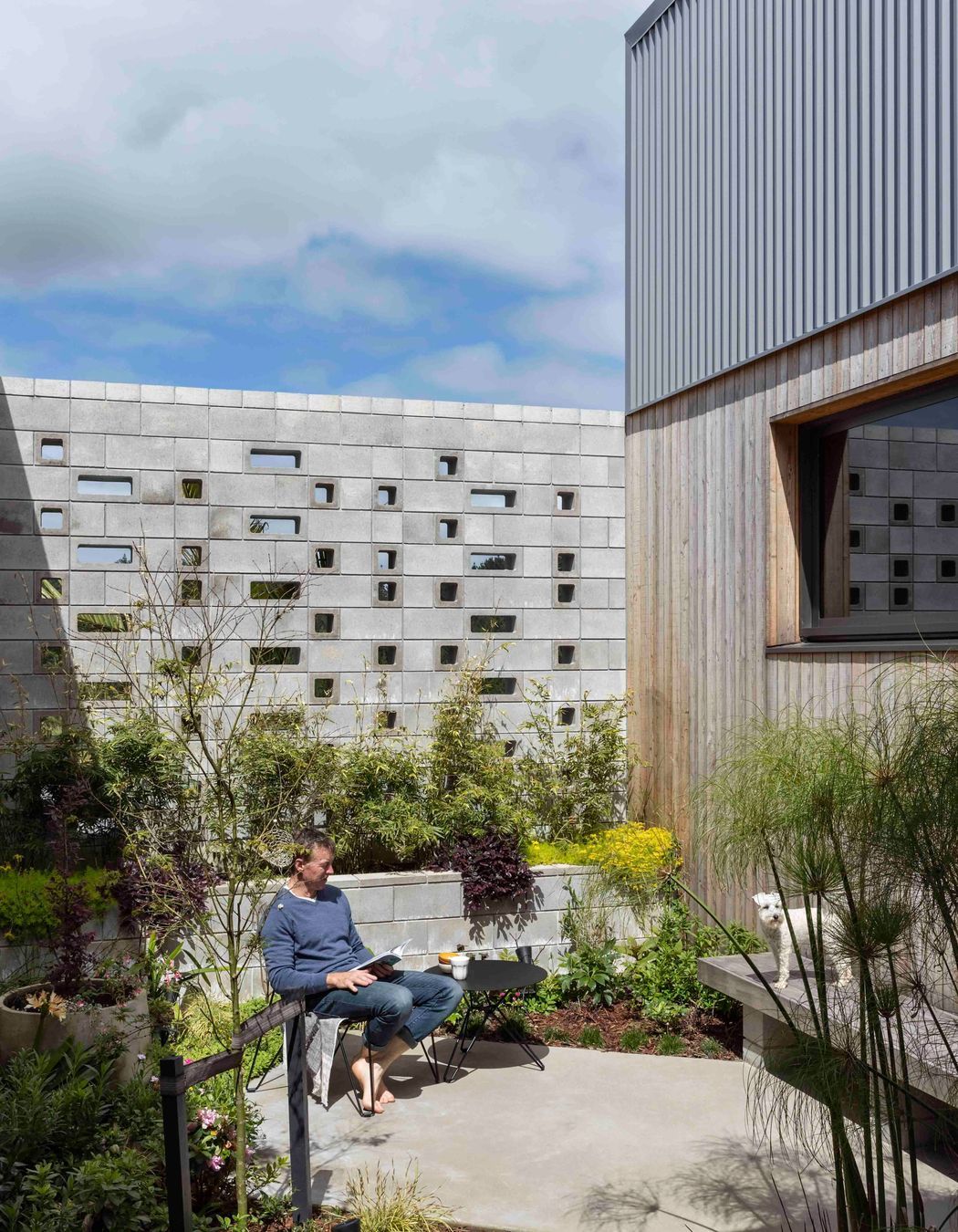 The external courtyard is stepped into the slope and protected by the perforated block wall.
