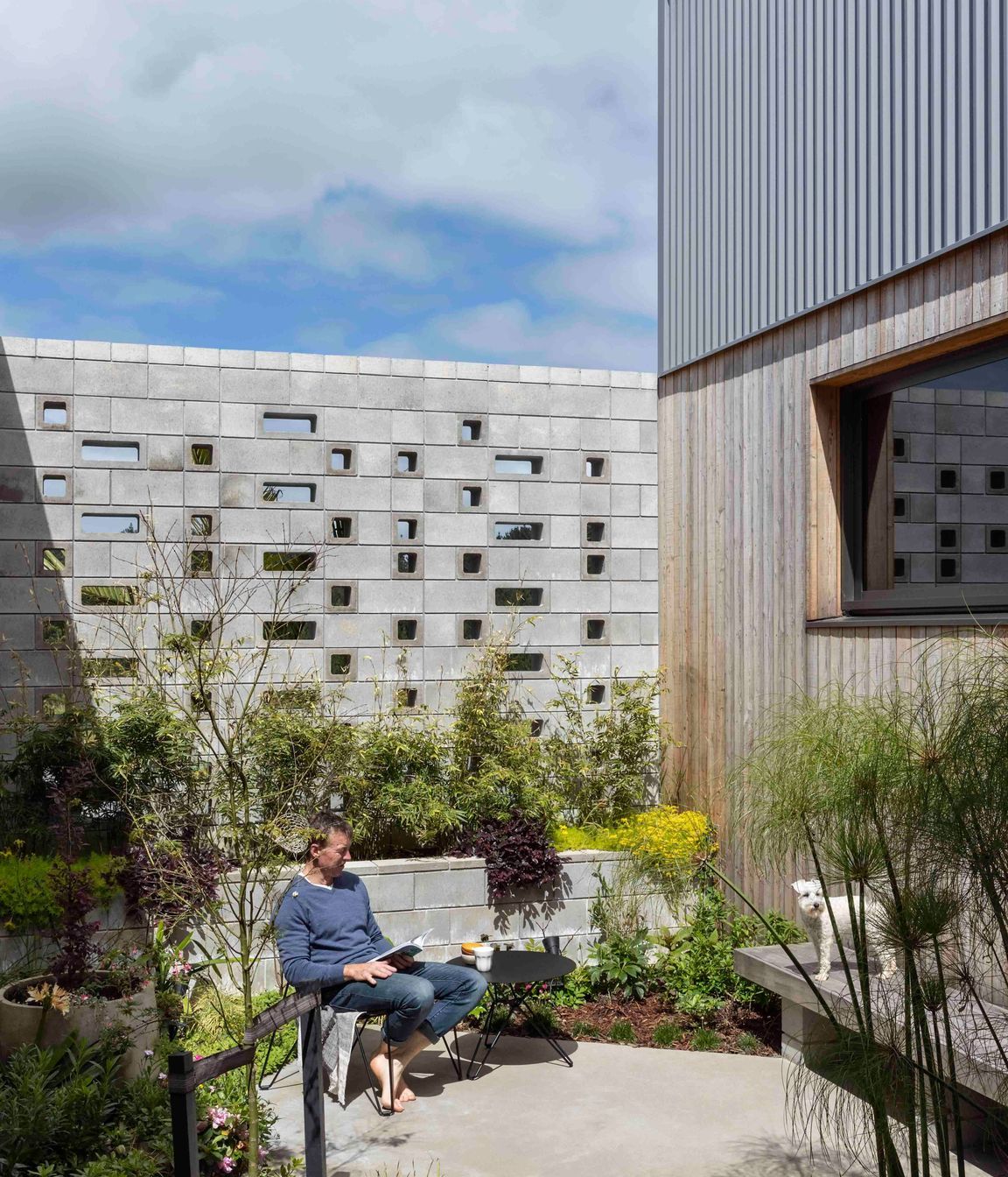 The external courtyard is stepped into the slope and protected by the perforated block wall.