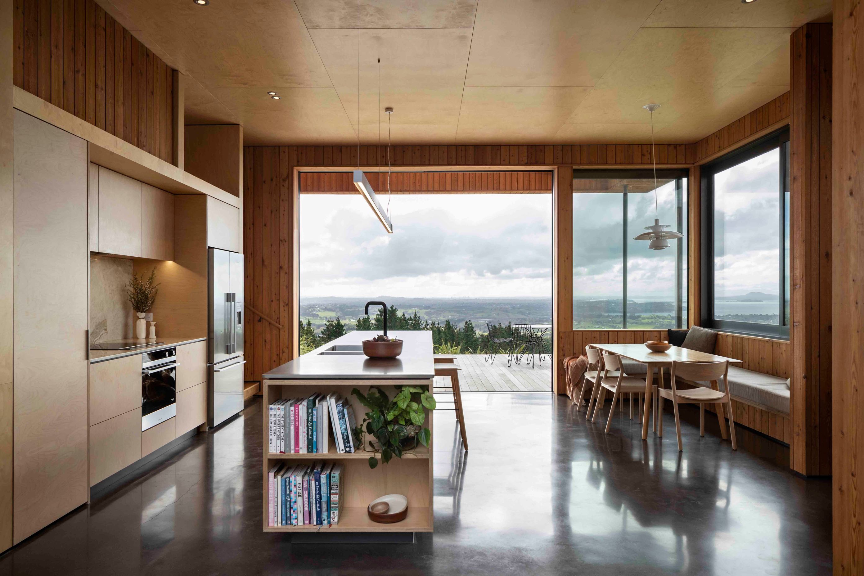 Birch plywood lines the ceiling of the kitchen, creating a biophilic tie to the outdoor spaces.