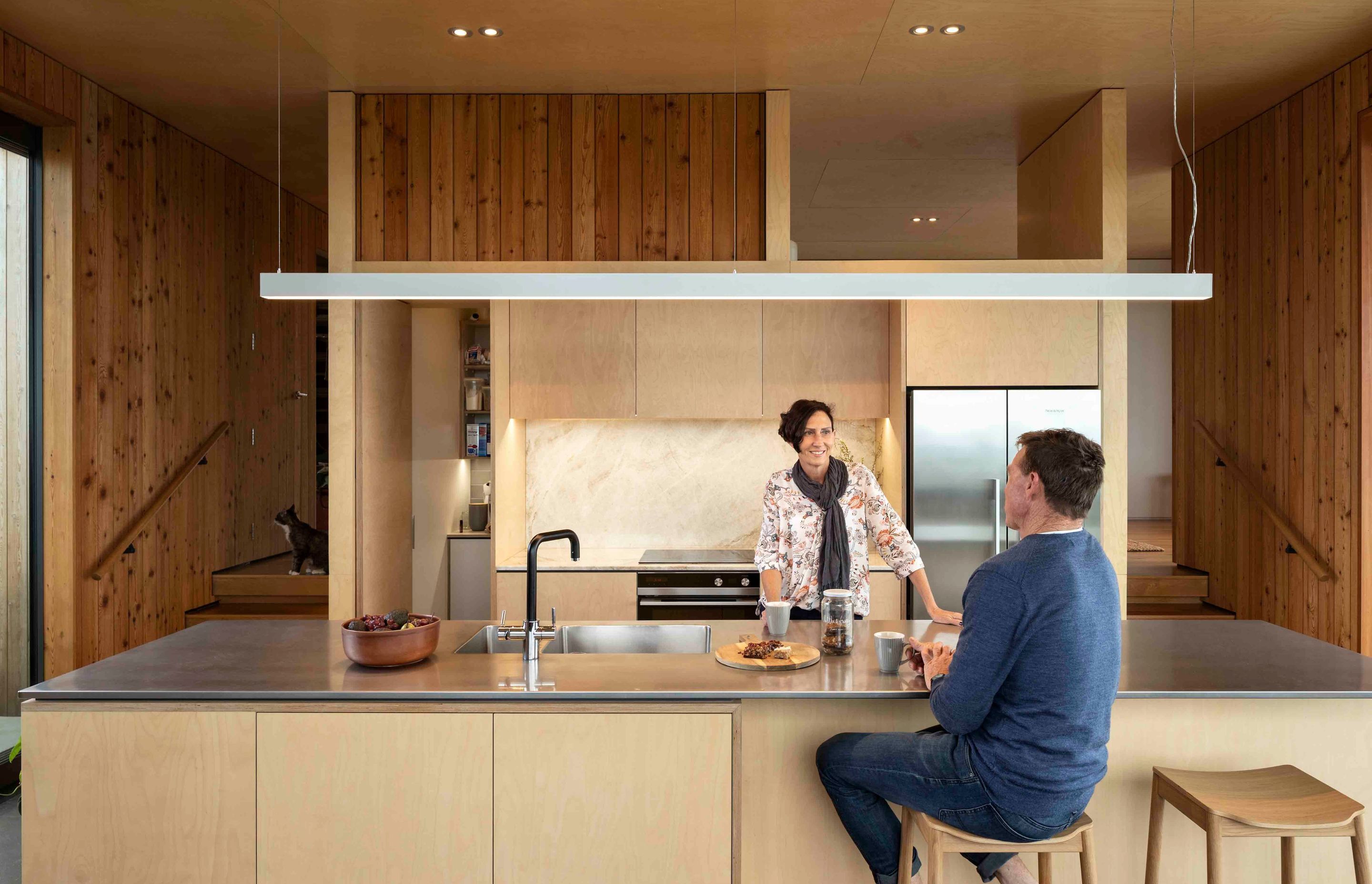 On either side of the kitchen, stairs access the different wings of the bedroom spaces.