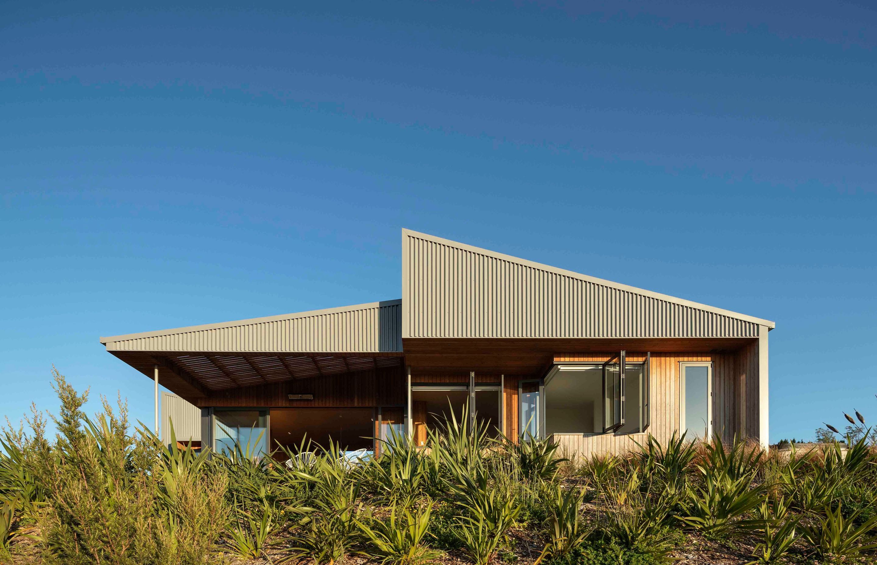 From the back of the house, the two strong triangular shapes of the house are in striking contrast to the natural setting.