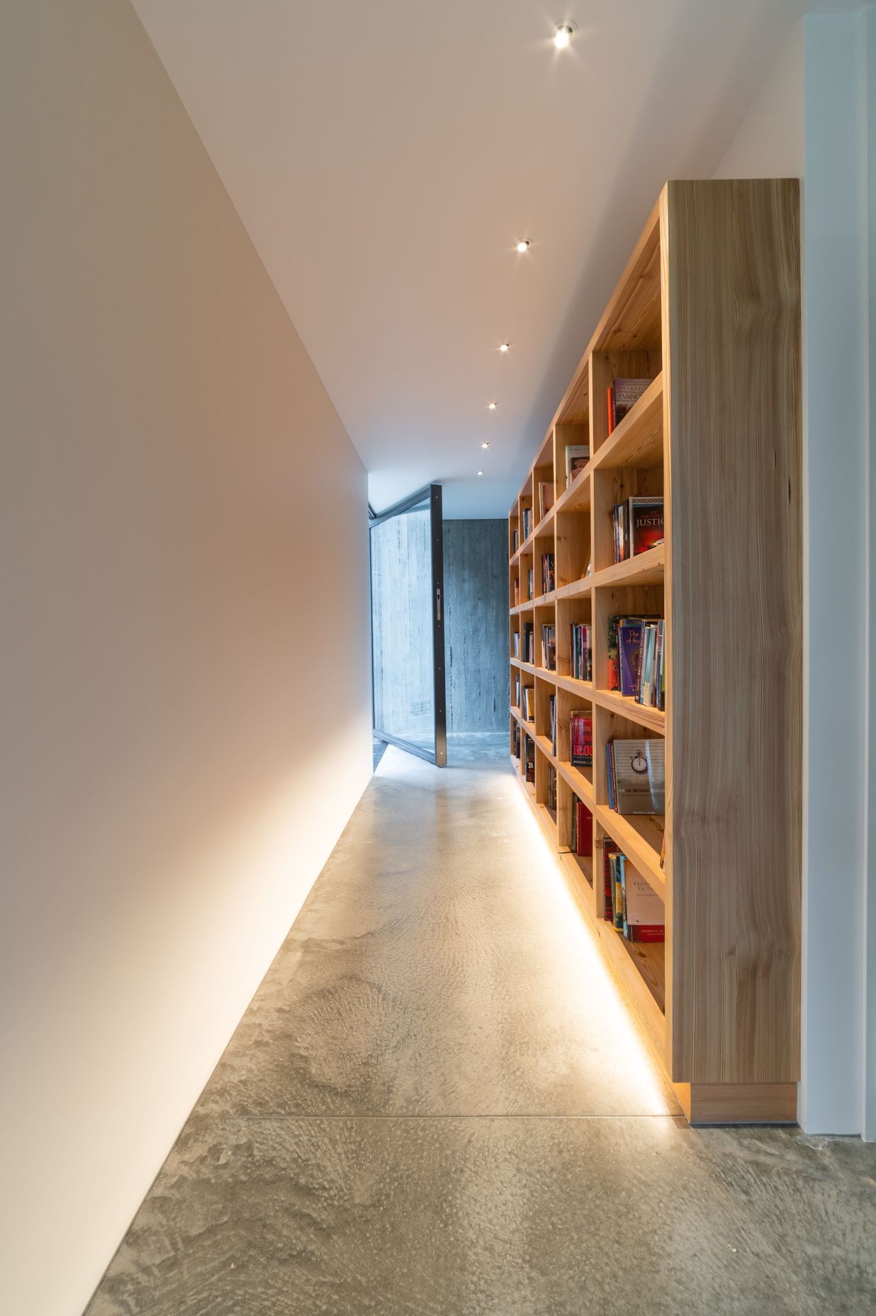 The glass entry door allows for seamless sightlines throughout the house to the cliff face behind.