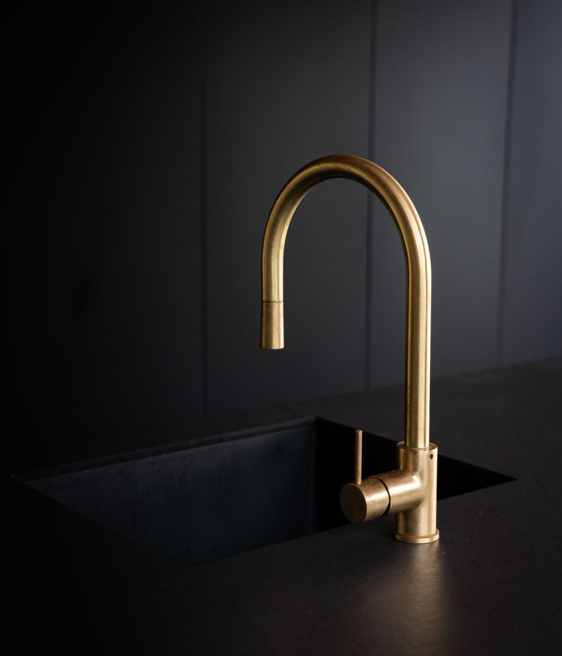 The Dekton benchtop has a unique velvet-like appearance, paired with elegant curved tapware.