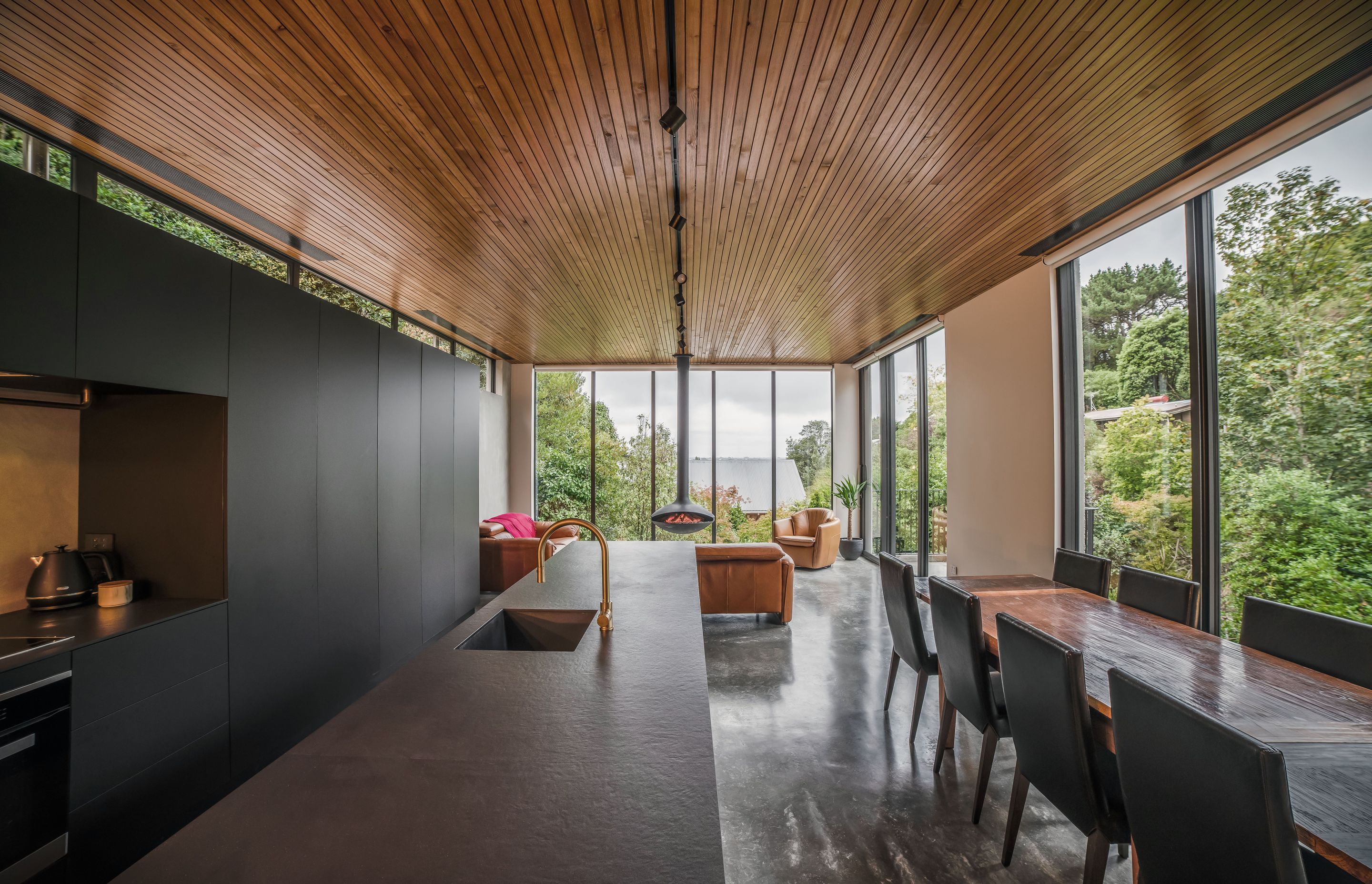 Matte cabinetry and a black benchtop with a unique velvet-like appearance maintain the pared back material palette.