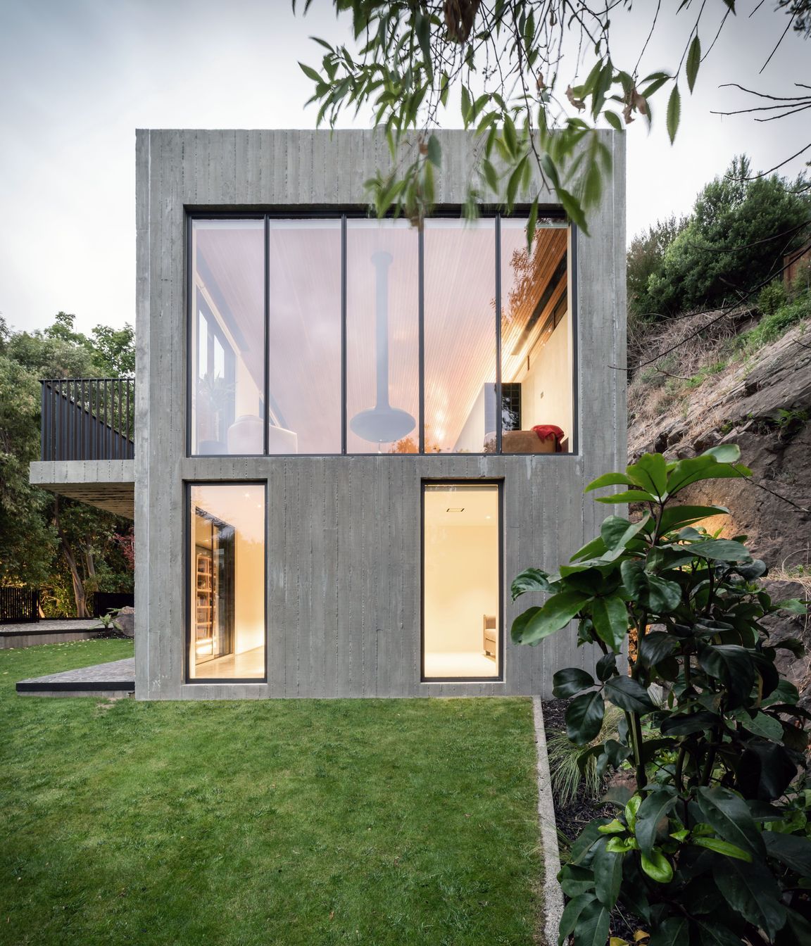 A suspended fire hangs in the centre of the main living room window, from which views down the valley, over Christchurch and to the Southern Alps beyond are captured.