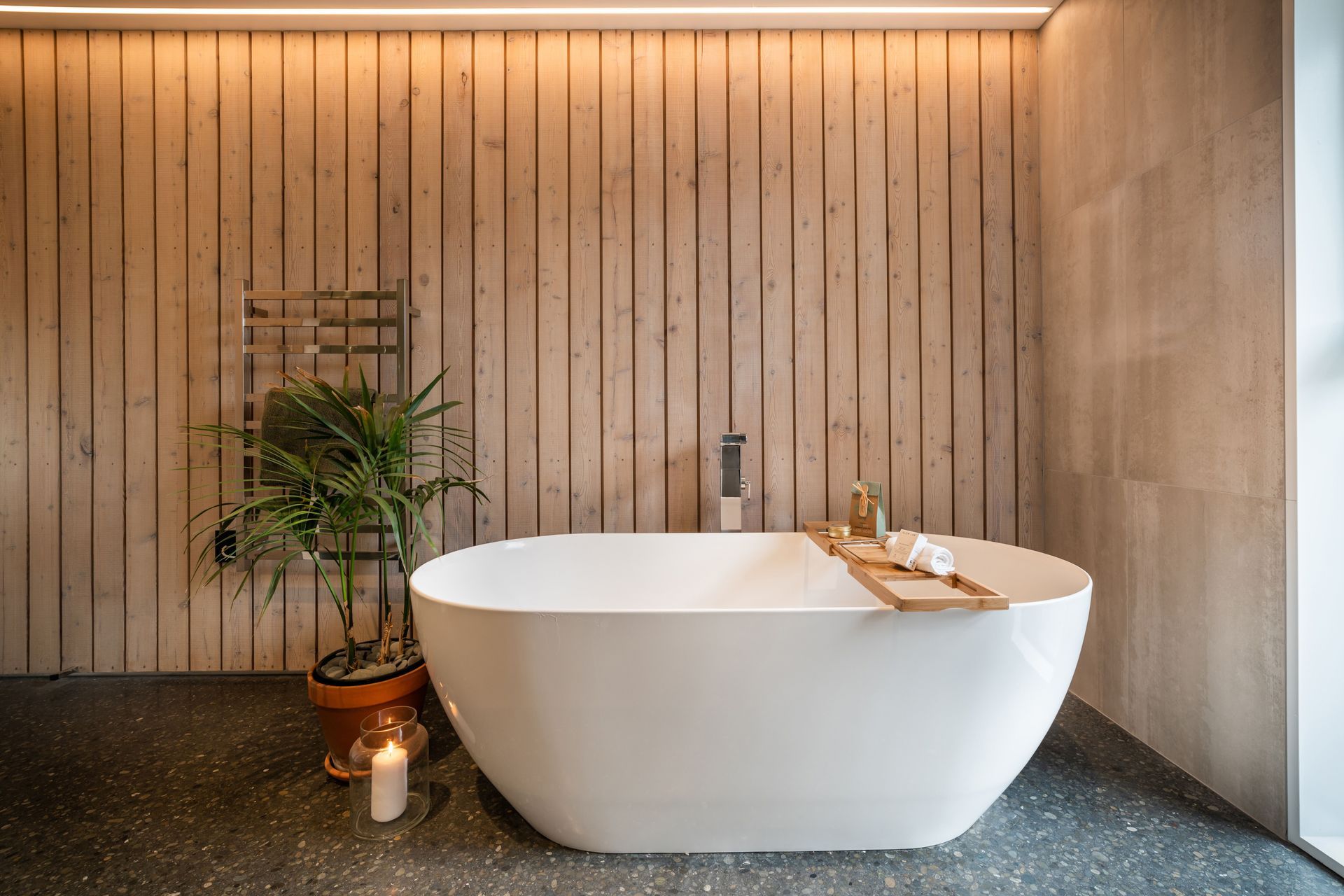 A striking larch wall is combined with tiles and a concrete floor to create a refined yet relaxed aesthetic.