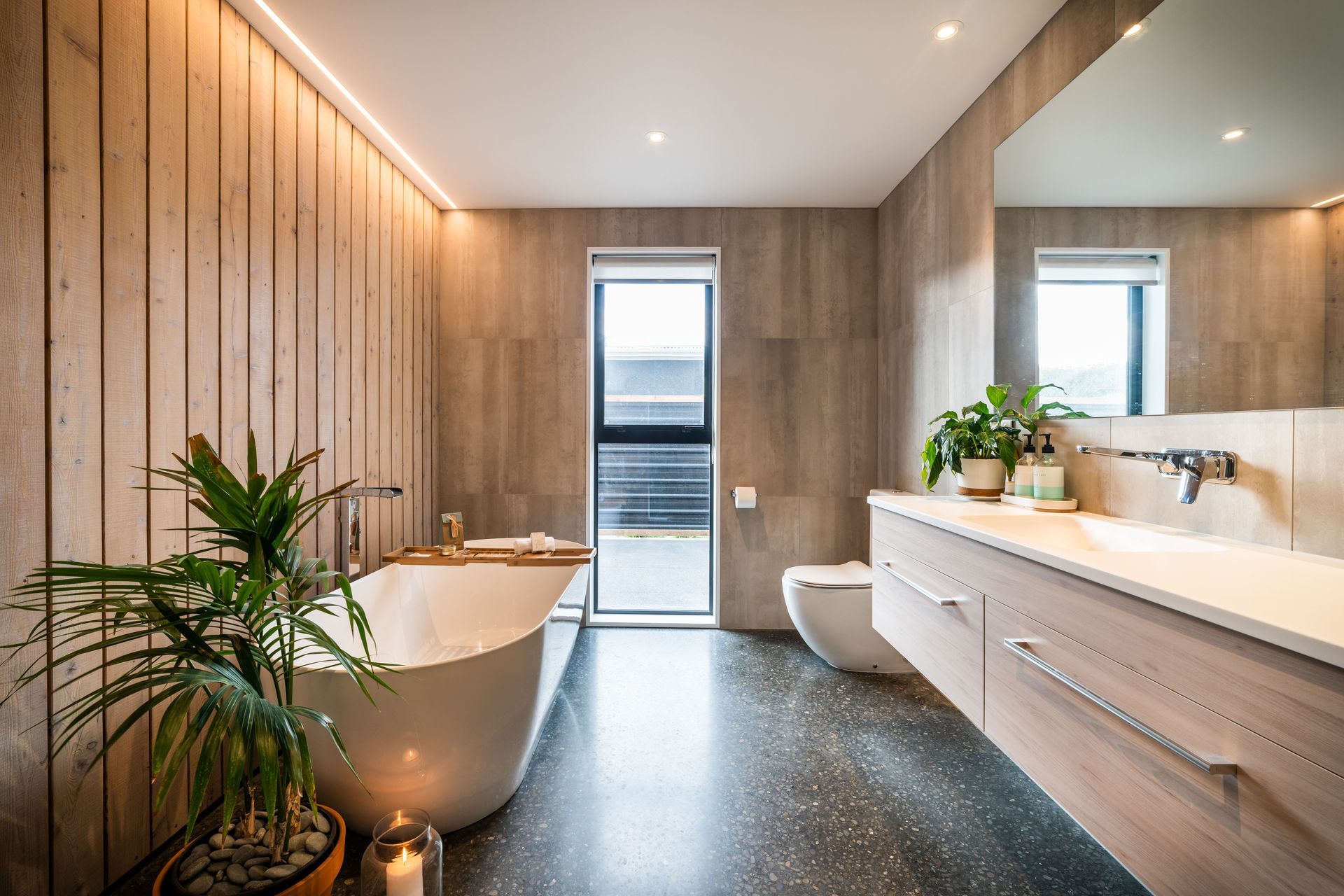 The main bathroom on the lower level features larch and tiles continuing the colour and material palette of the rest of the house.