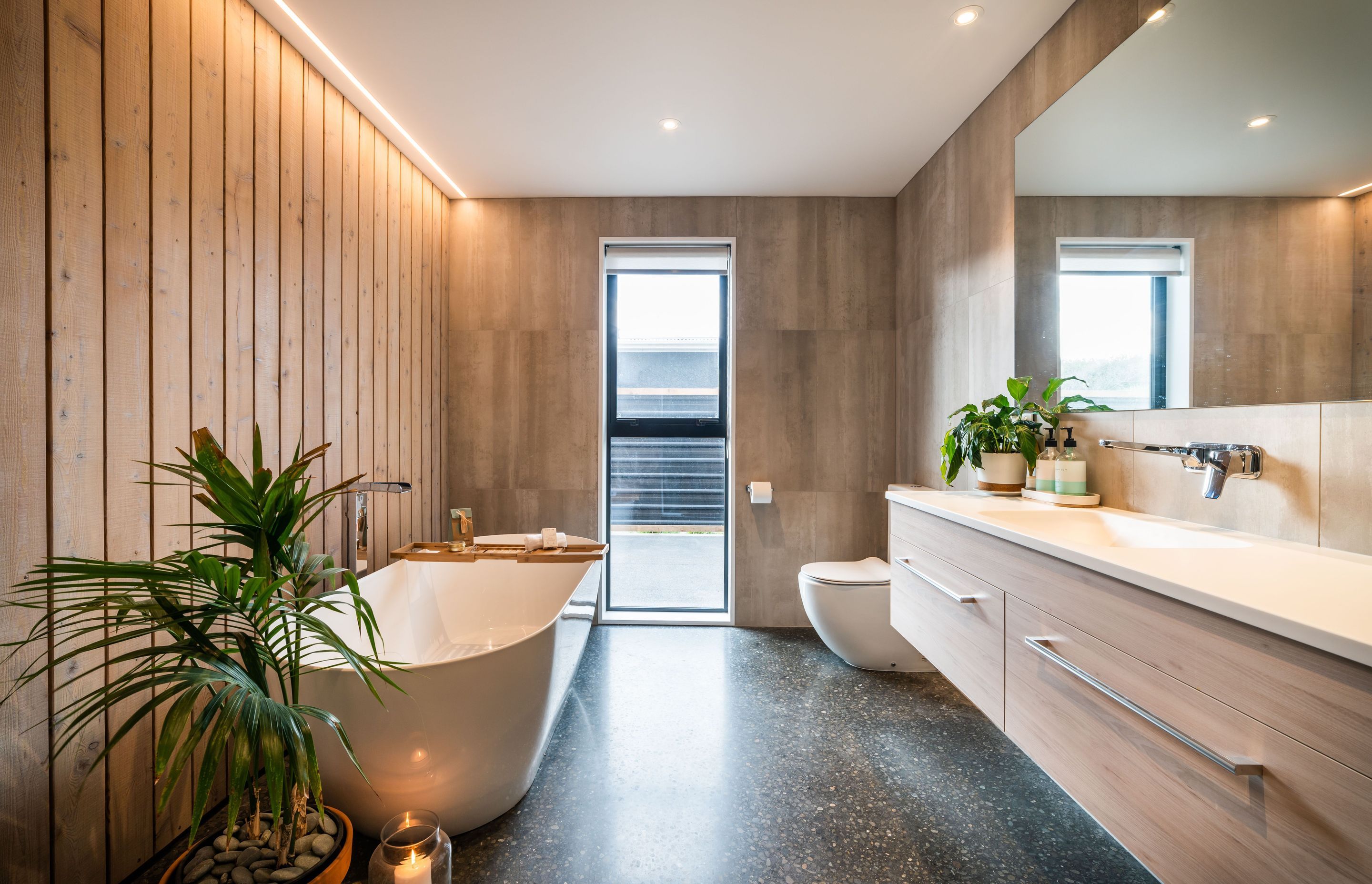 The main bathroom on the lower level features larch and tiles continuing the colour and material palette of the rest of the house.