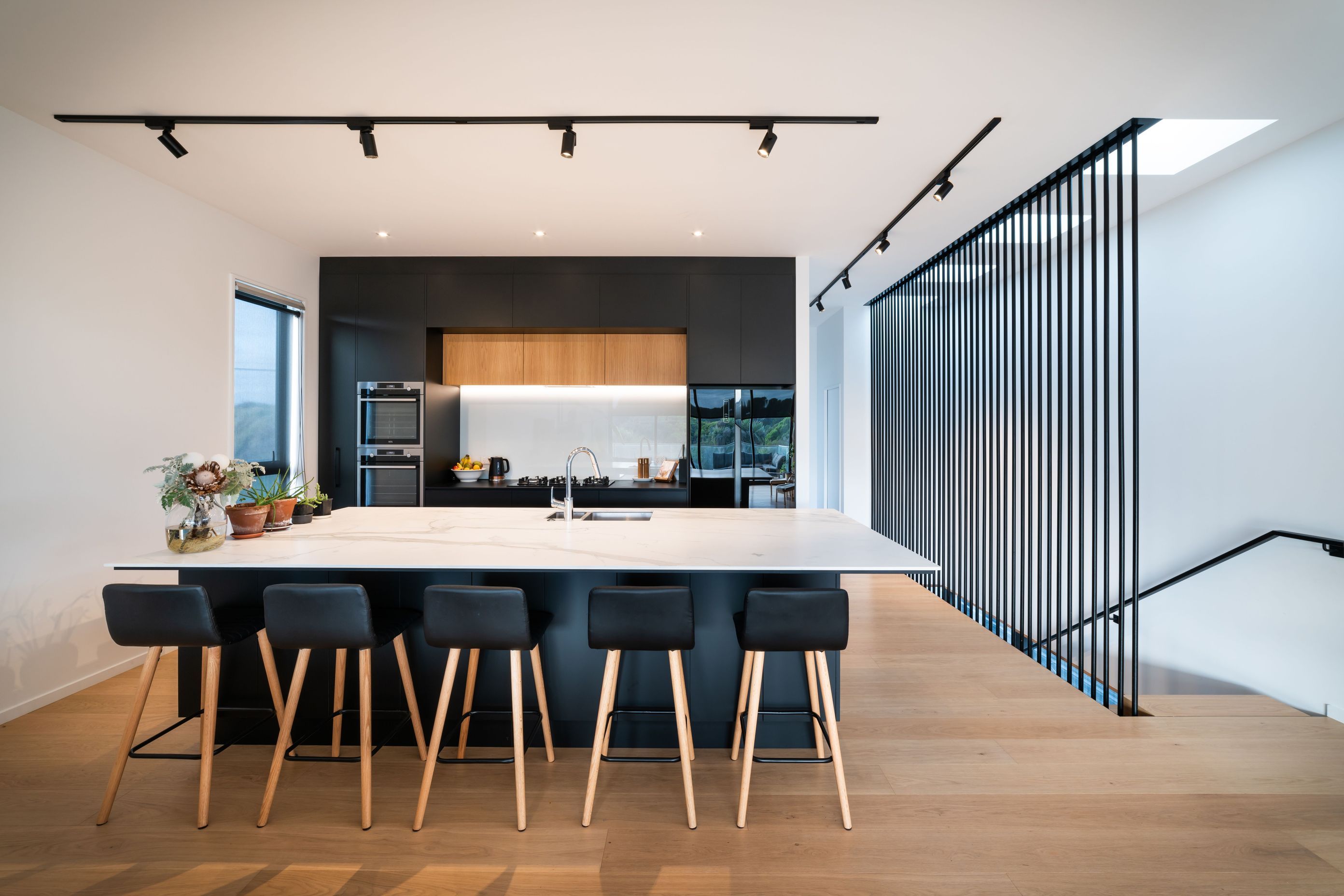 Upstairs, the palette pares back with an open-plan area of monochromatic hues coupled with a timber floor. 