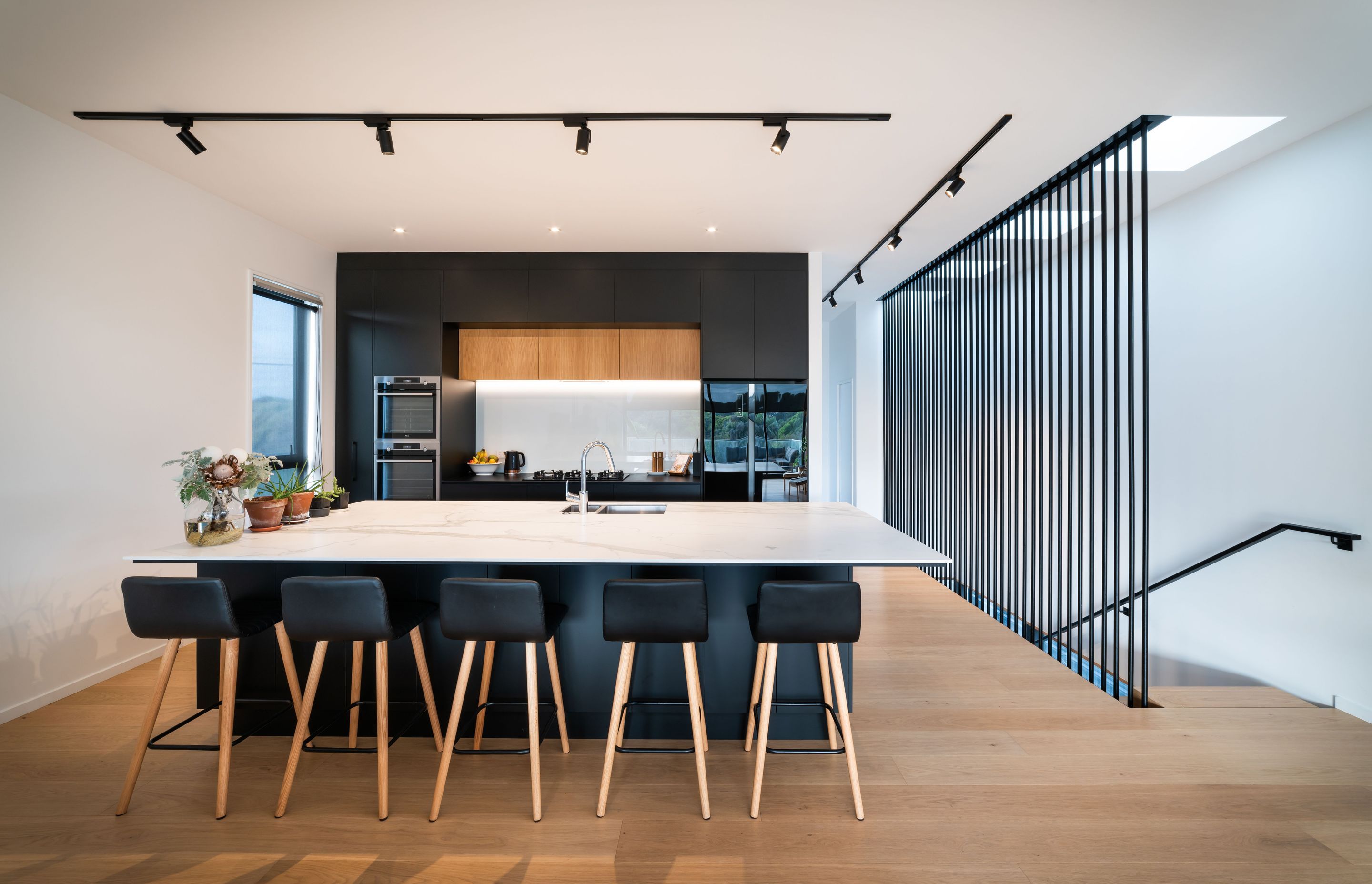 Upstairs, the palette pares back with an open-plan area of monochromatic hues coupled with a timber floor.
