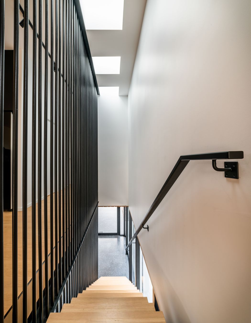 The verticality of the black steel balustrade works to draw visitors up to the main living area.