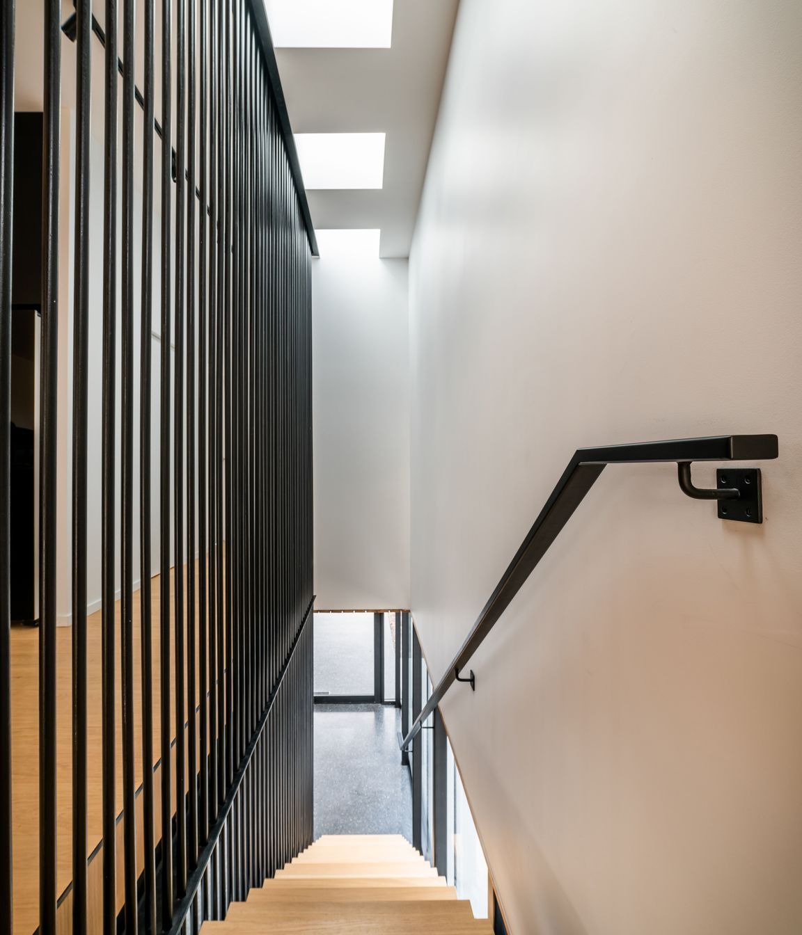 The verticality of the black steel balustrade works to draw visitors up to the main living area.