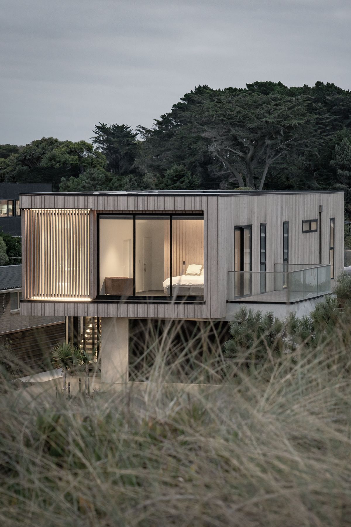 Occupying the entire cantilevered area, a spacious en suite shower room is shielded with larch fins.