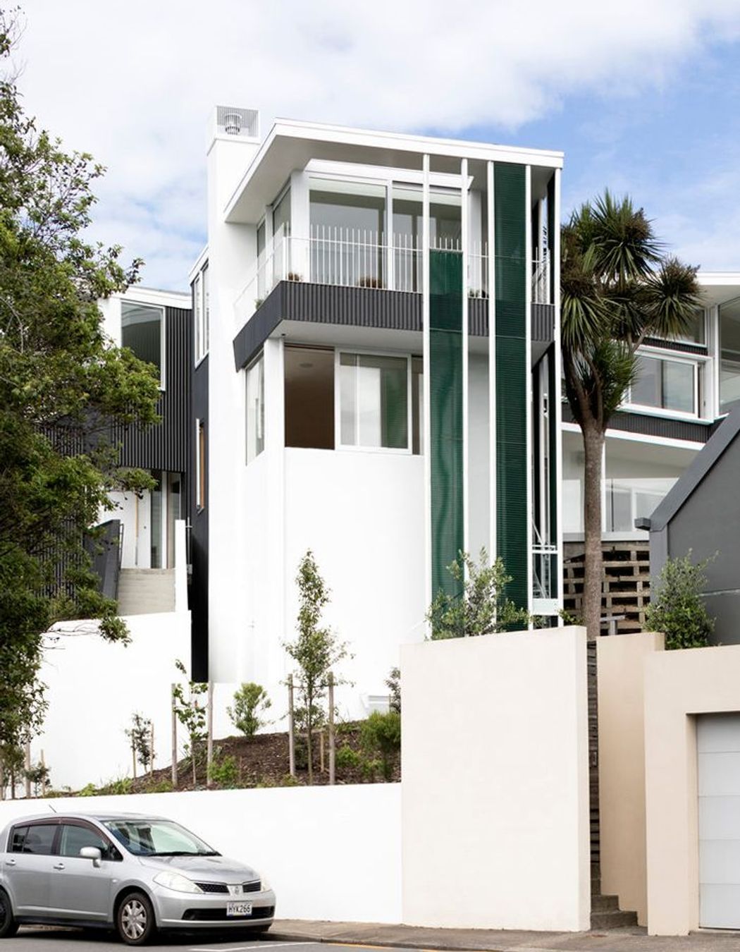 The northern elevation from Salmont Place features jade-green vertical mesh screens.