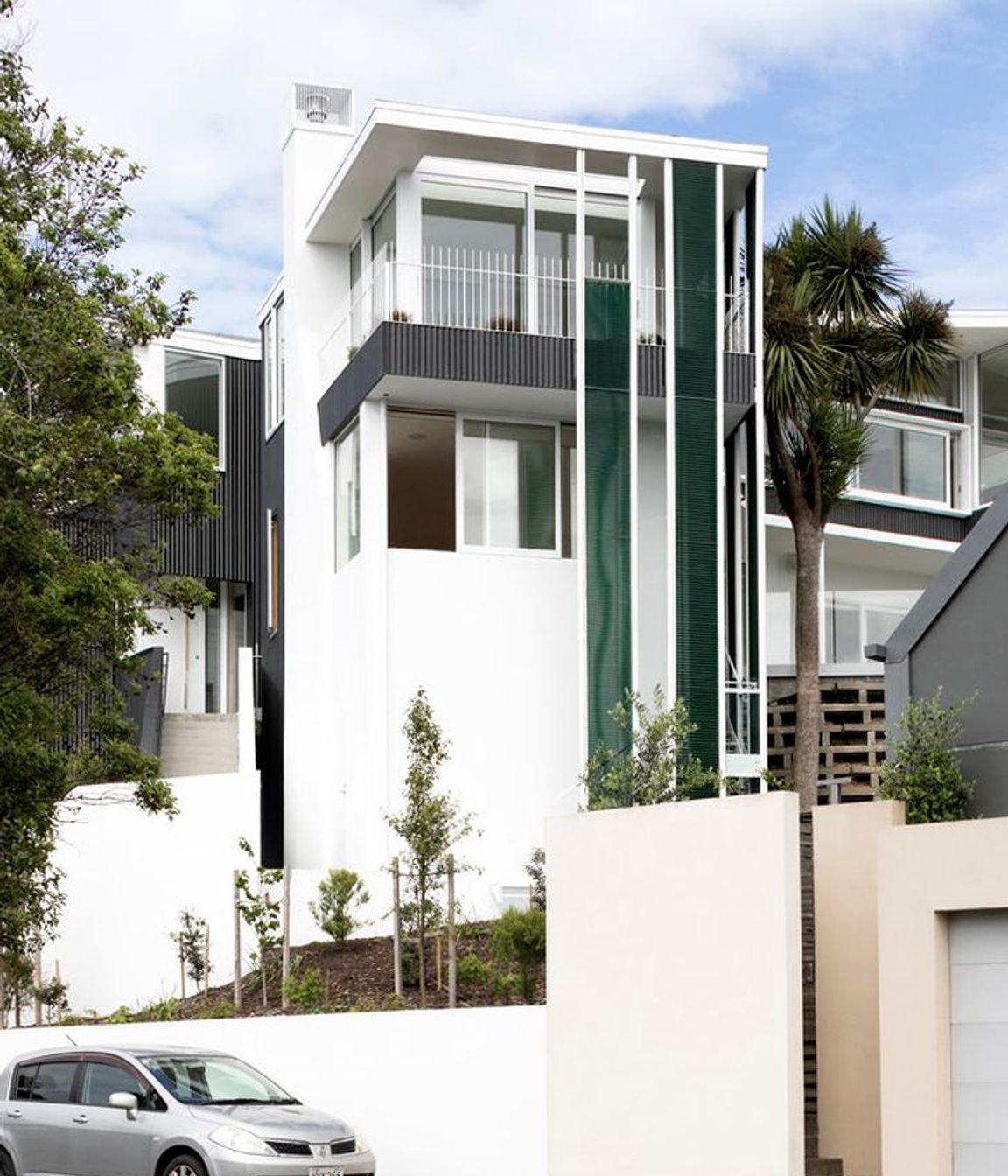 The northern elevation from Salmont Place features jade-green vertical mesh screens.