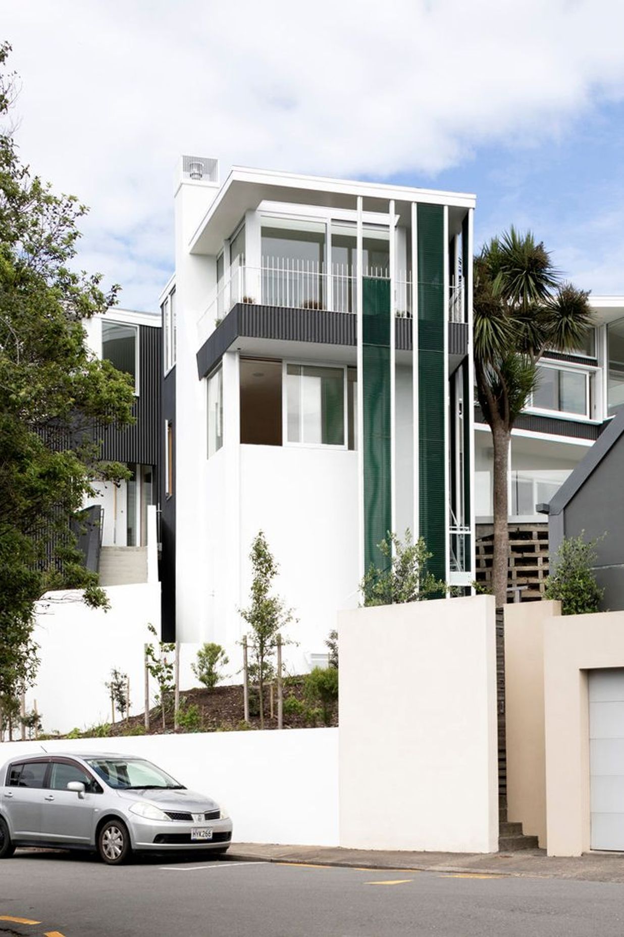 The northern elevation from Salmont Place features jade-green vertical mesh screens.