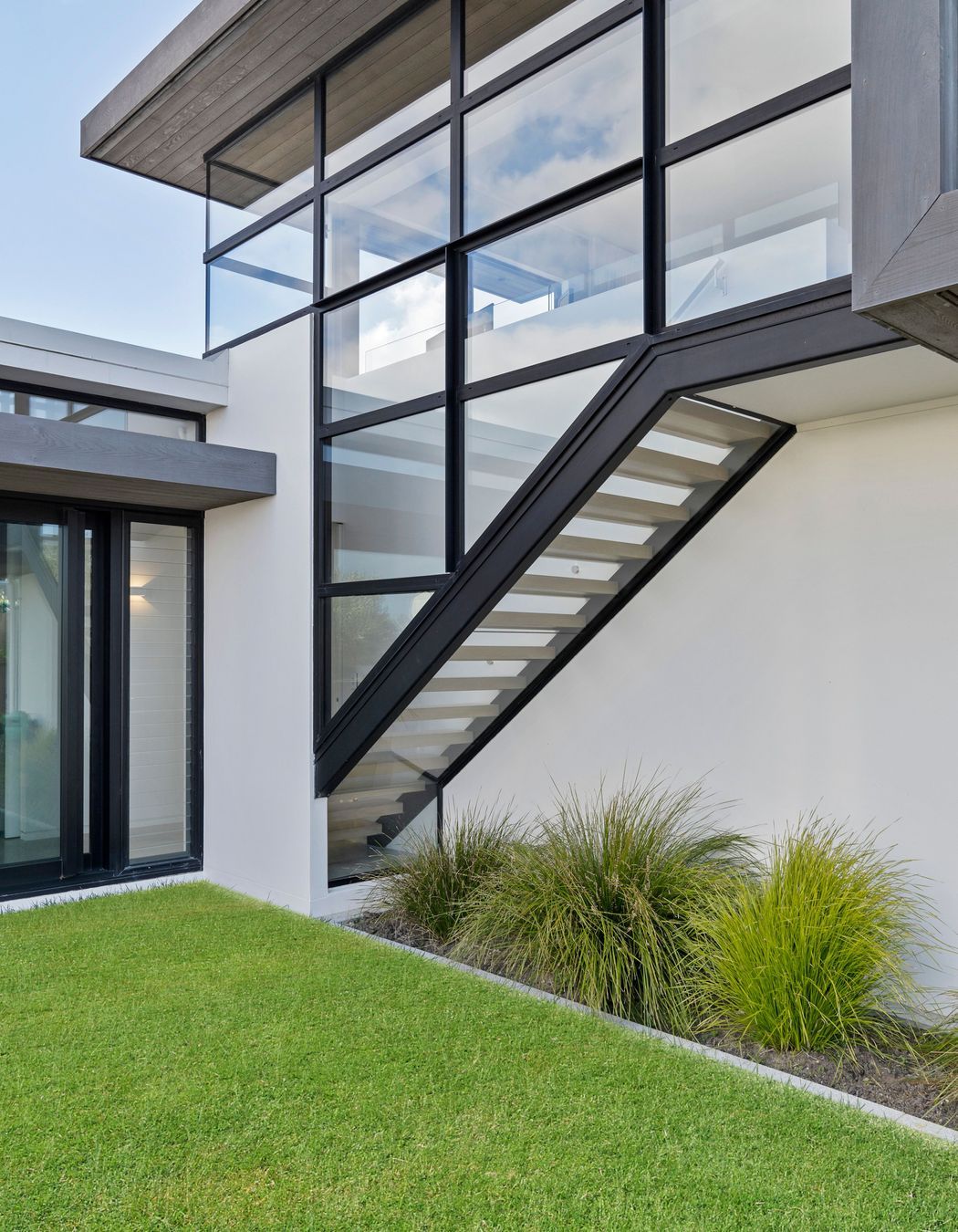 Floating glass encased staircase leads up to the master bedroom