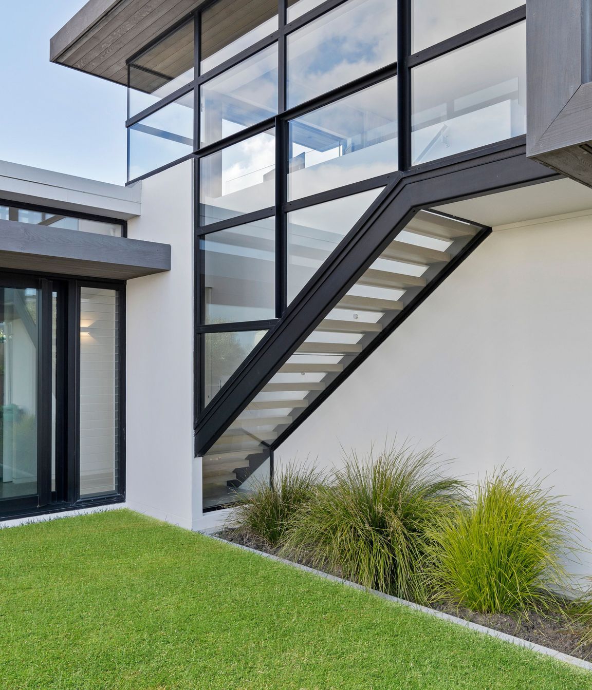 Floating glass encased staircase leads up to the master bedroom
