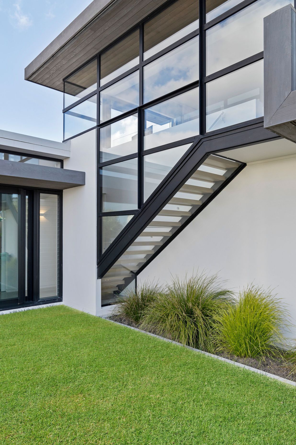 Floating glass encased staircase leads up to the master bedroom