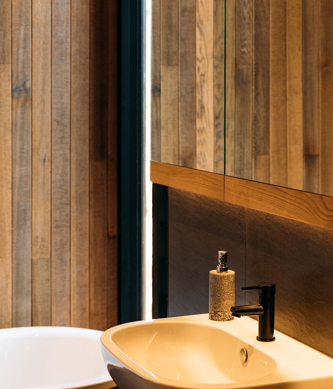 Oahu matt porcelain tiles add textural contrast to the cedar in the main bathroom.