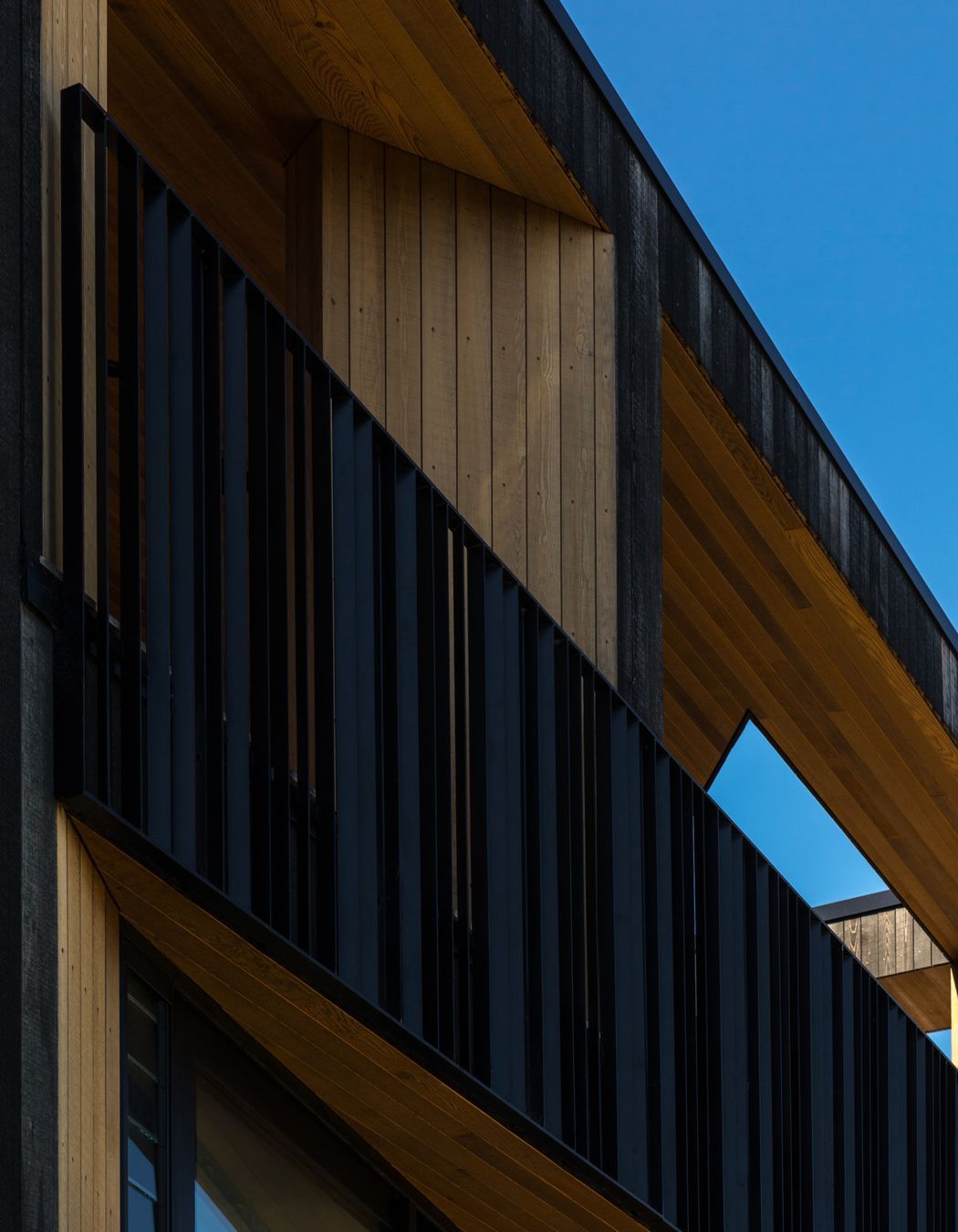 Faceted angles are juxtaposed against bold vertical and horizontal lines, reinforced by the steel balustrade.