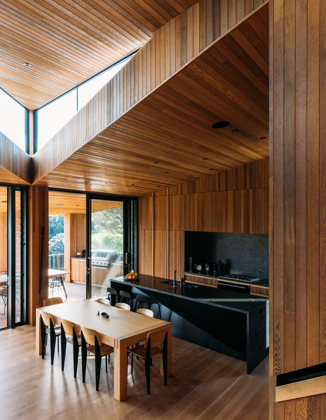 The architect wanted the stark exterior to give way to a rich, timber-lined interior that referenced, in a contemporary way, the area's original baches that sprang up post-WWII