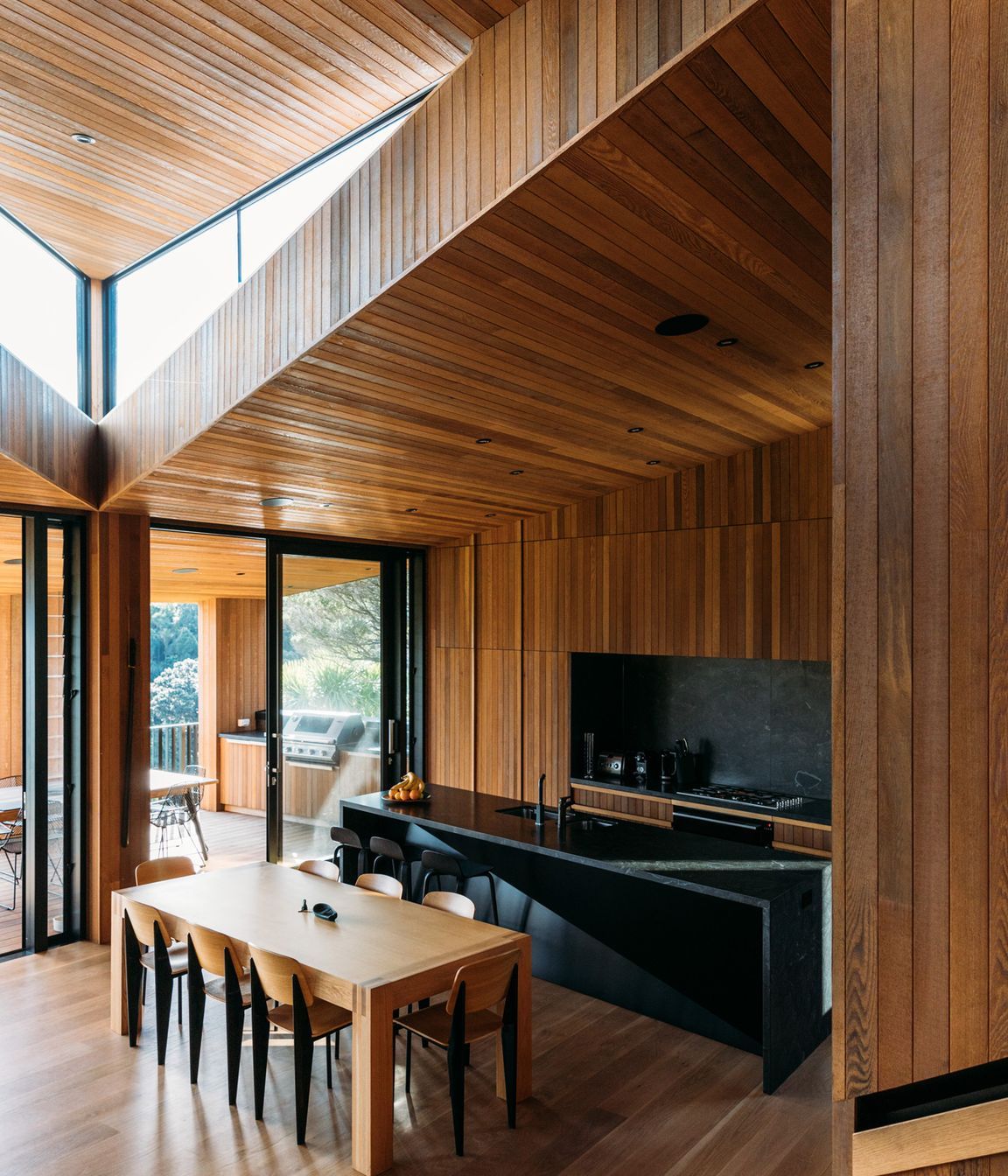 The architect wanted the stark exterior to give way to a rich, timber-lined interior that referenced, in a contemporary way, the area's original baches that sprang up post-WWII