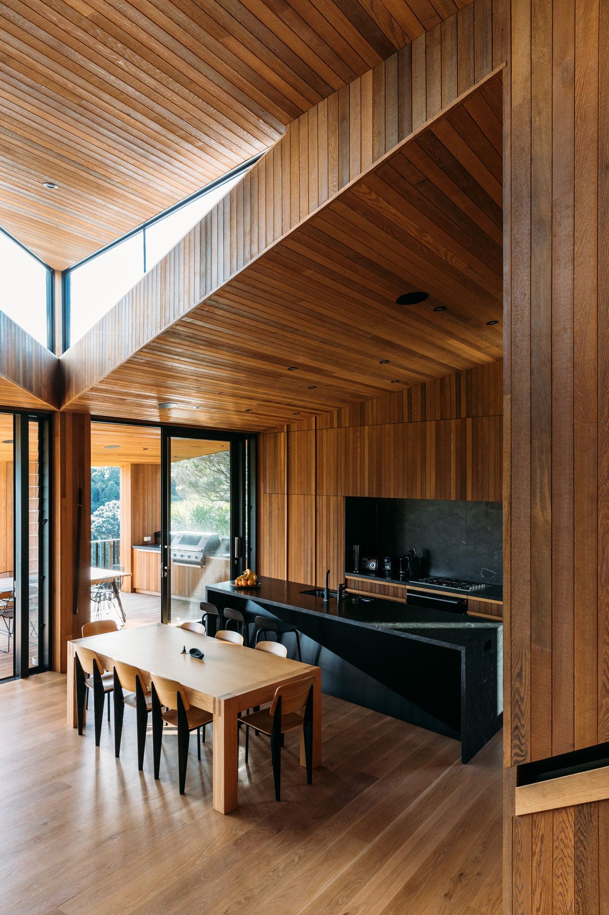 The architect wanted the stark exterior to give way to a rich, timber-lined interior that referenced, in a contemporary way, the area's original baches that sprang up post-WWII