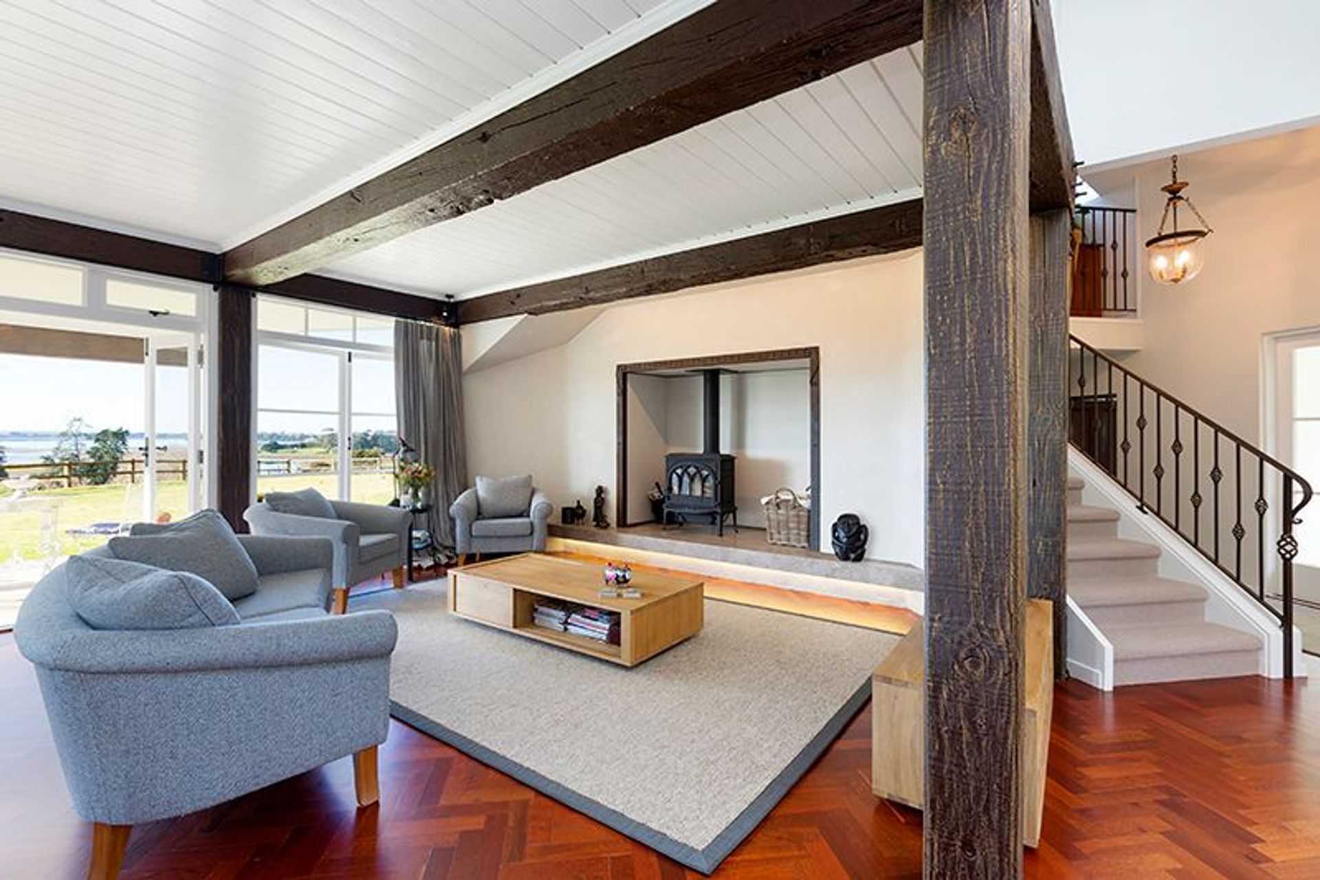 Family room, Artisan Flooring leather bound custom rug, bespoke wrought iron balustrade to stairwell