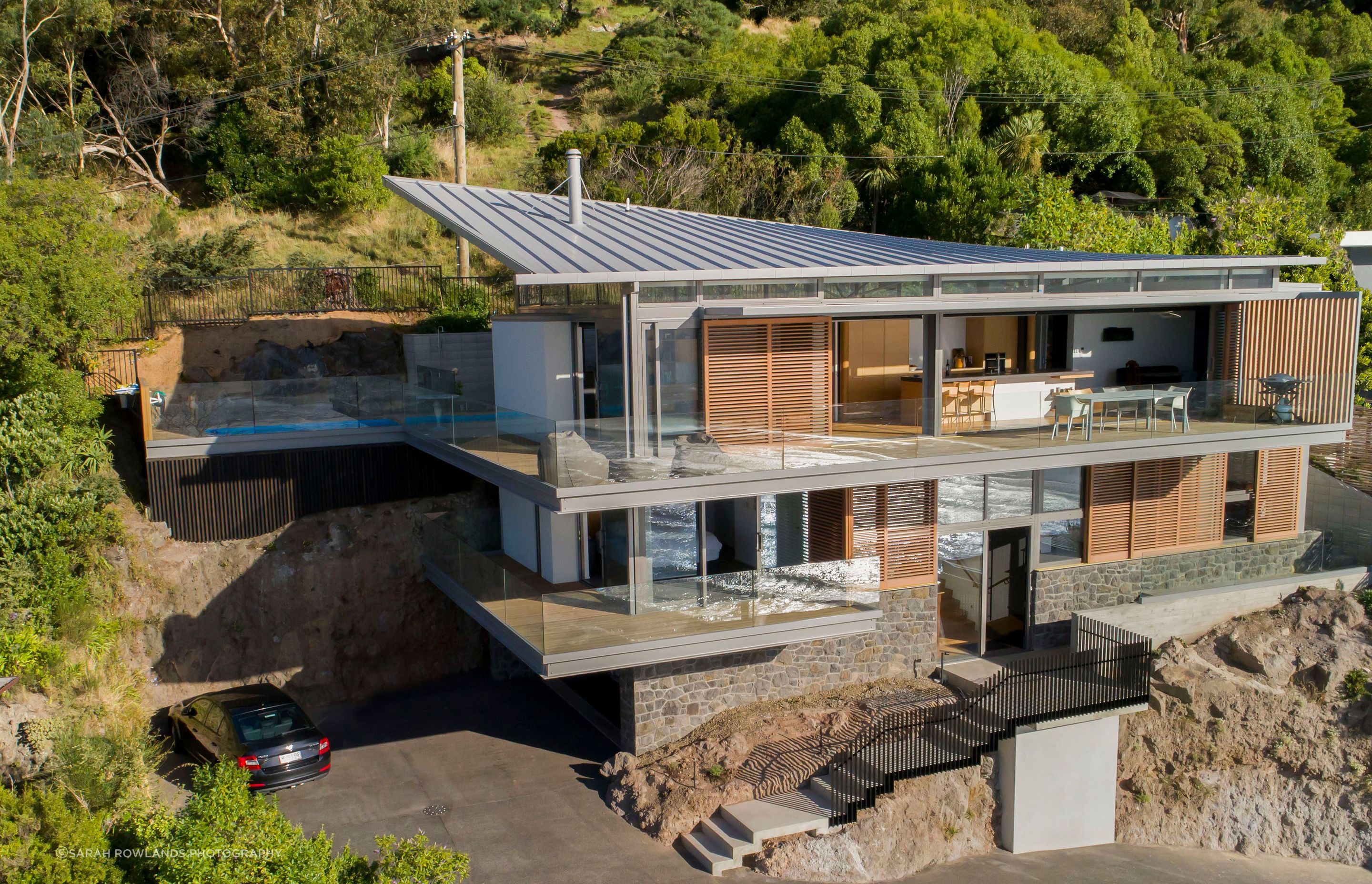 While the house appears to emerge directly from the rock, it is in fact sitting free of the cliff face, a condition of the building consent.