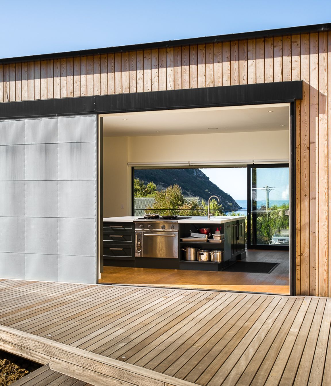 The industrial door opens up the 'evening' deck to a view of the ocean.