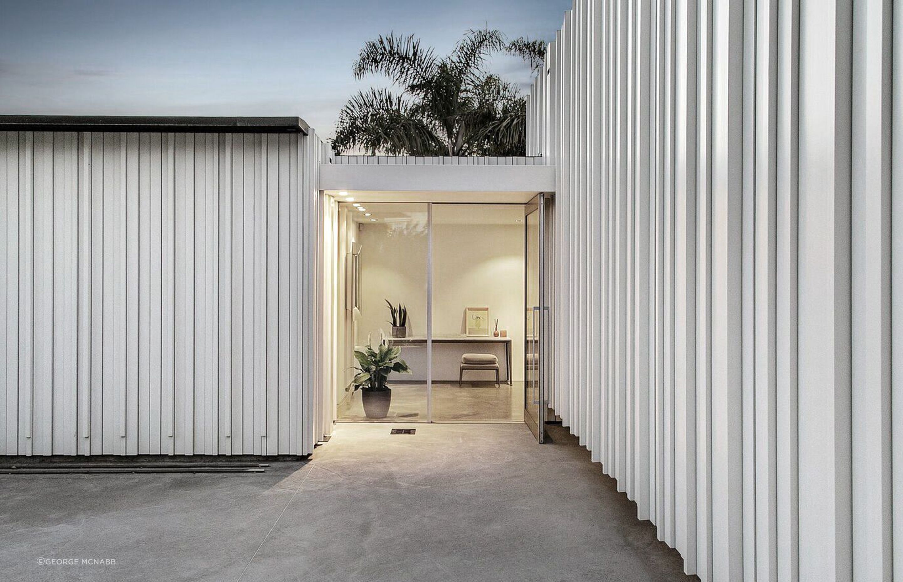 The glazed main entrance is framed by painted timber cladding which is carried through into the interior.