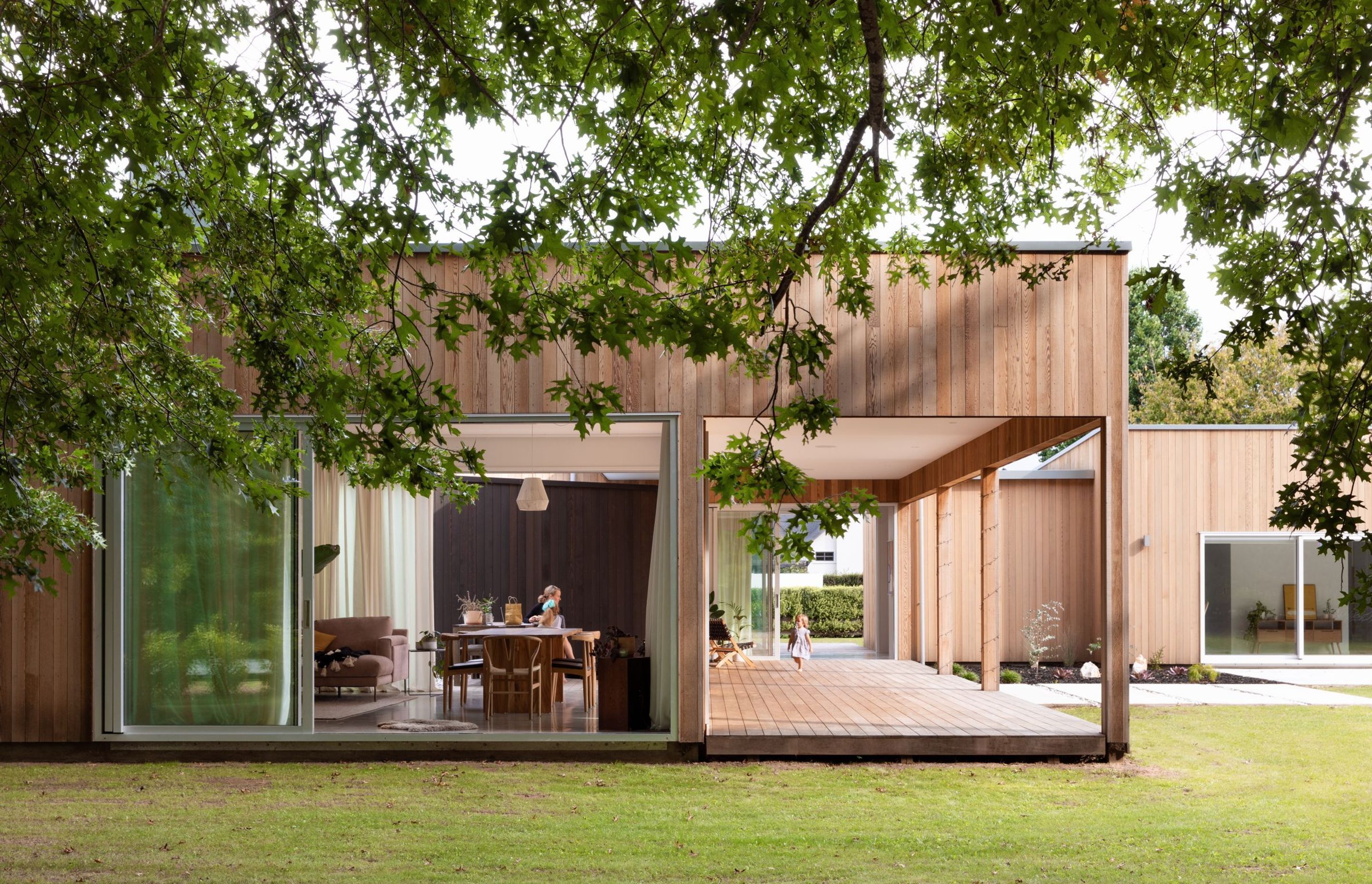 A large verandah extends the living space outside. The house is stripped of adornment and presents a strong, minimal composition. 